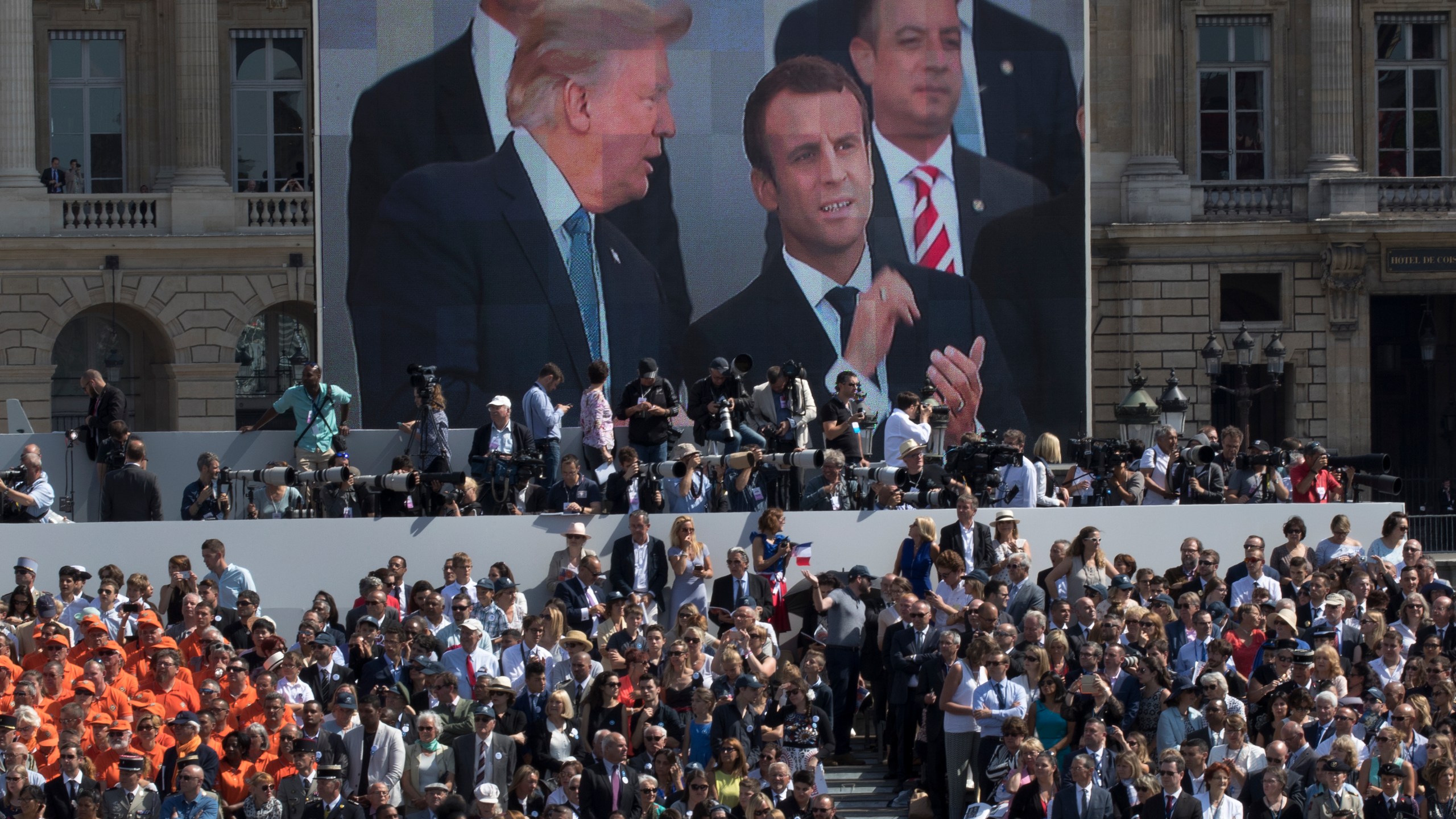 FILE - President Donald Trump, pictured on screen from left, French President Emmanuel Macron and White House Chief of Staff Reince Priebus watch a Bastille Day parade on the Champs Elysees avenue in Paris, July 14, 2017. (AP Photo/Carolyn Kaster, File)