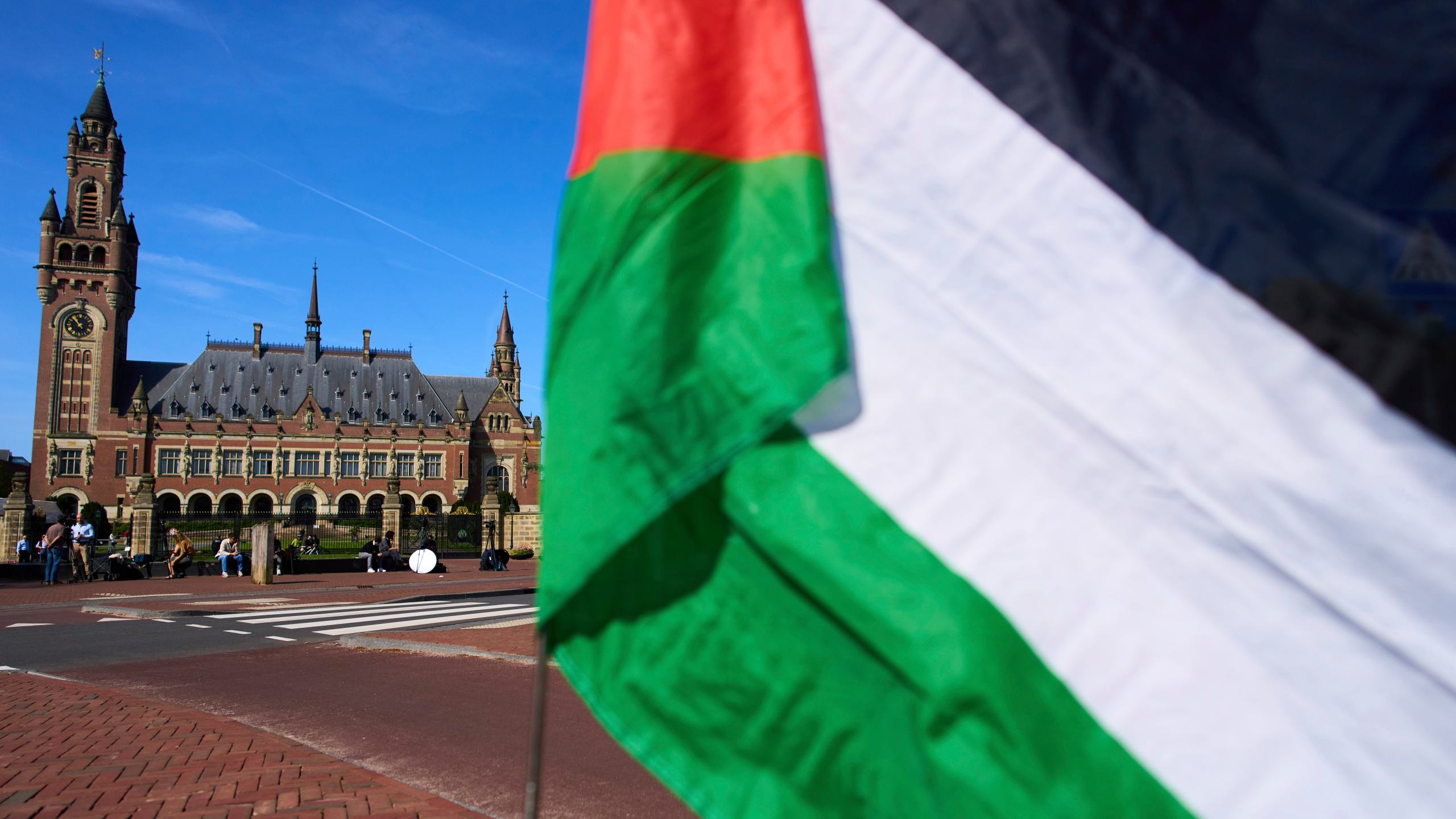 A Palestinian flag flies outside the International Court of Justice, rear, which opened hearings into a United Nations request for an advisory opinion on Israel's obligations to allow humanitarian assistance in Gaza and the West Bank, in The Hague, Netherlands, Monday, April 28, 2025. (AP Photo/Peter Dejong)