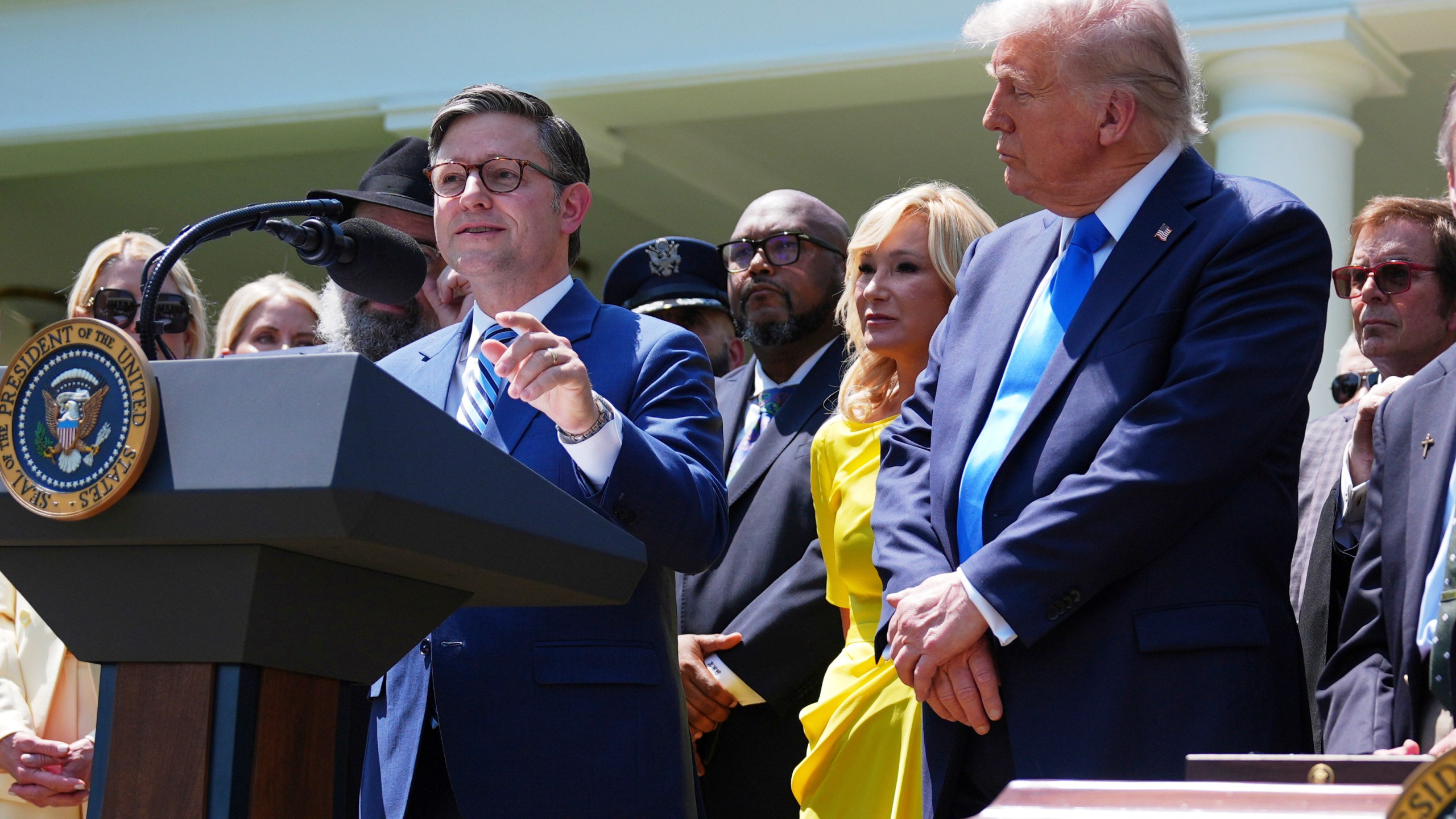 House Speaker Mike Johnson, R-La., speaks as President Donald Trump, right, listens during a National Day of Prayer event in the Rose Garden of the White House, Thursday, May 1, 2025, in Washington. (AP Photo/Evan Vucci)