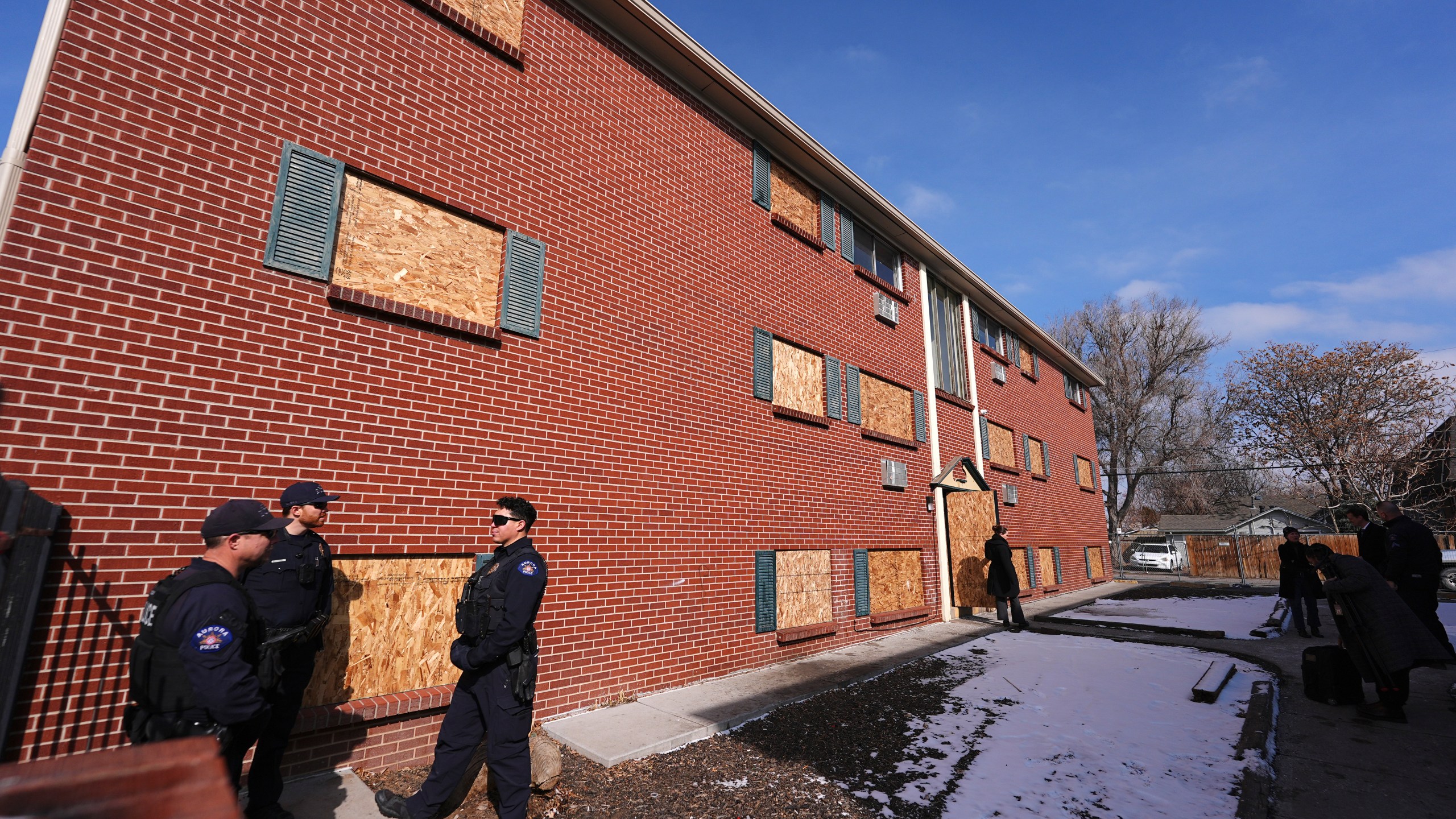 FILE - Officers gather outside one of the condemned buildings of an apartment complex called The Edge at Lowry after a news conference to outline that the five housing structures have been closed by the city, Feb. 19, 2025, in Aurora, Colo. (AP Photo/David Zalubowski, File)
