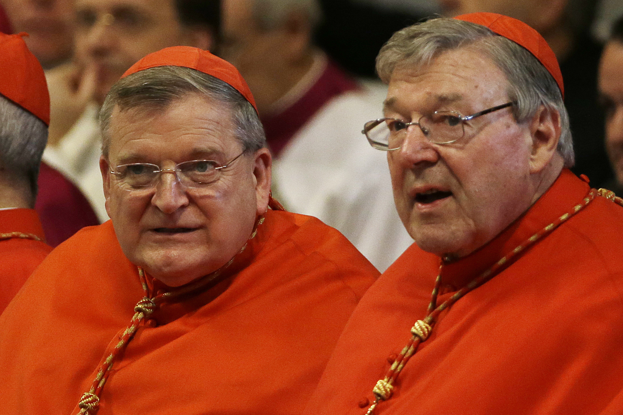 FILE - Cardinal Raymond Leo Burke, left, and Cardinal George Pell wait for the arrival of Pope Francis in St. Peter's Basilica at the Vatican, June 29, 2015. (AP Photo/Gregorio Borgia, File)