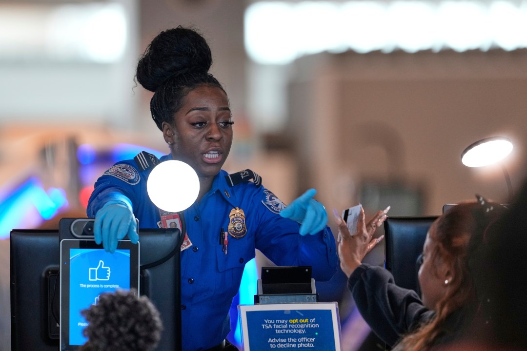 A TSA employee checks IDs as people move through security at Newark Liberty International Airport in Newark, N.J., Wednesday, May 7, 2025. (AP Photo/Seth Wenig)