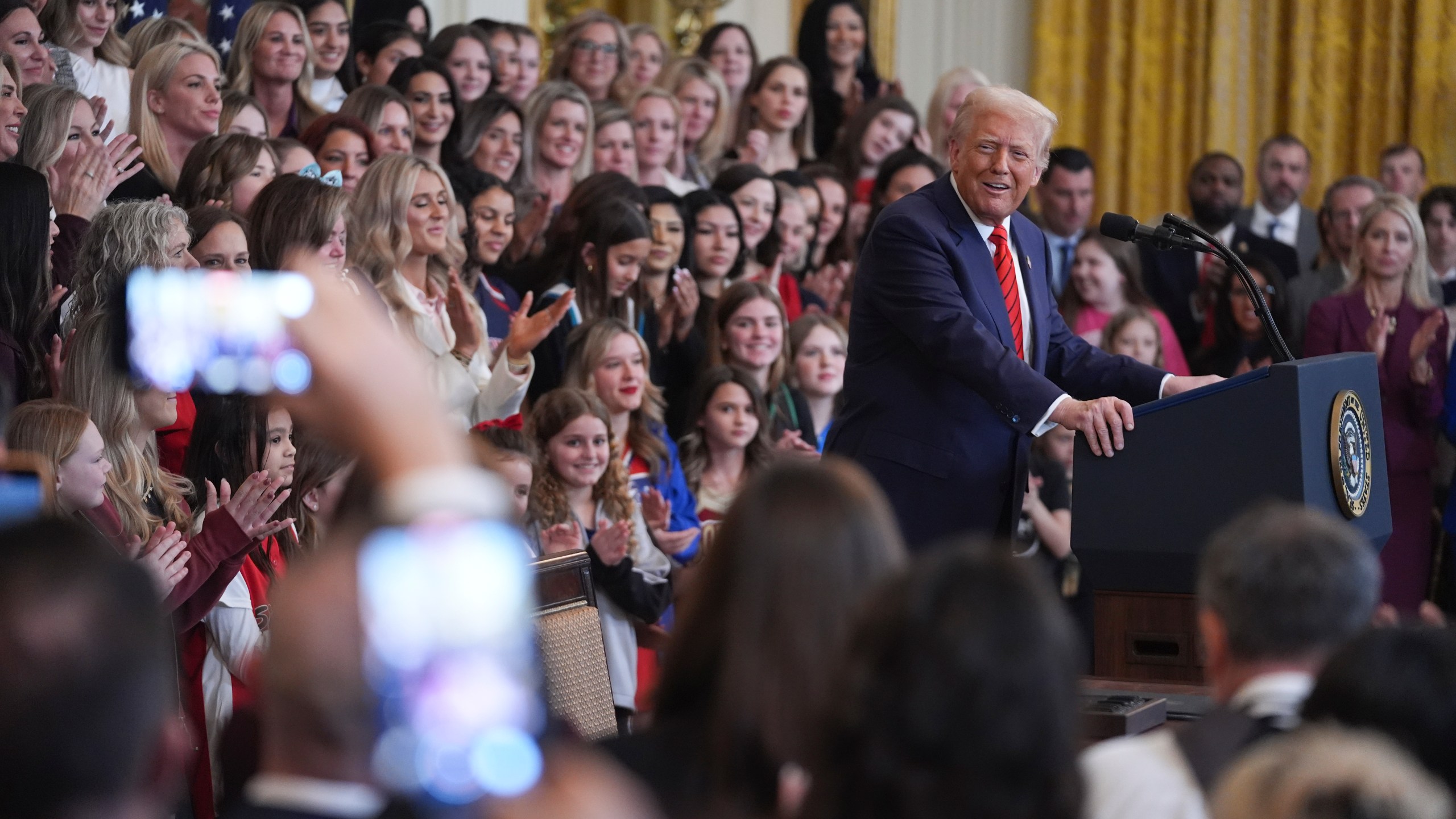 FILE - Women and girls look on as President Donald Trump speaks before signing an executive order barring transgender female athletes from competing in women's or girls' sporting events, in the East Room of the White House, Wednesday, Feb. 5, 2025, in Washington.(AP Photo/ Evan Vucci, File)