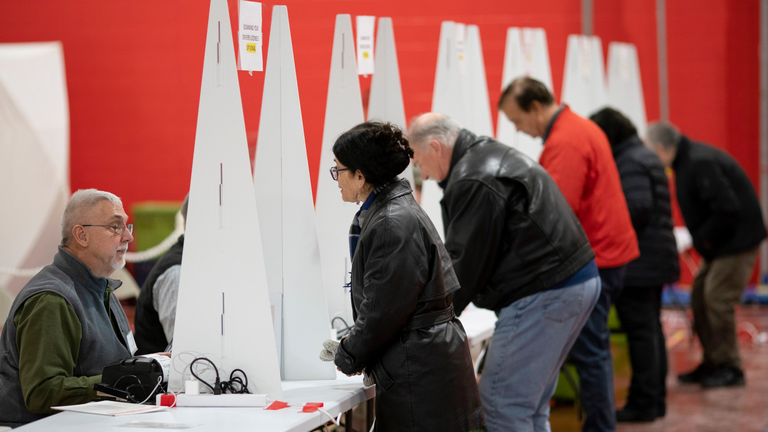 FILE - Voters check in to cast ballots in the New Hampshire presidential primary at a polling site in Derry, N.H., Jan. 23, 2024. (AP Photo/David Goldman, File)
