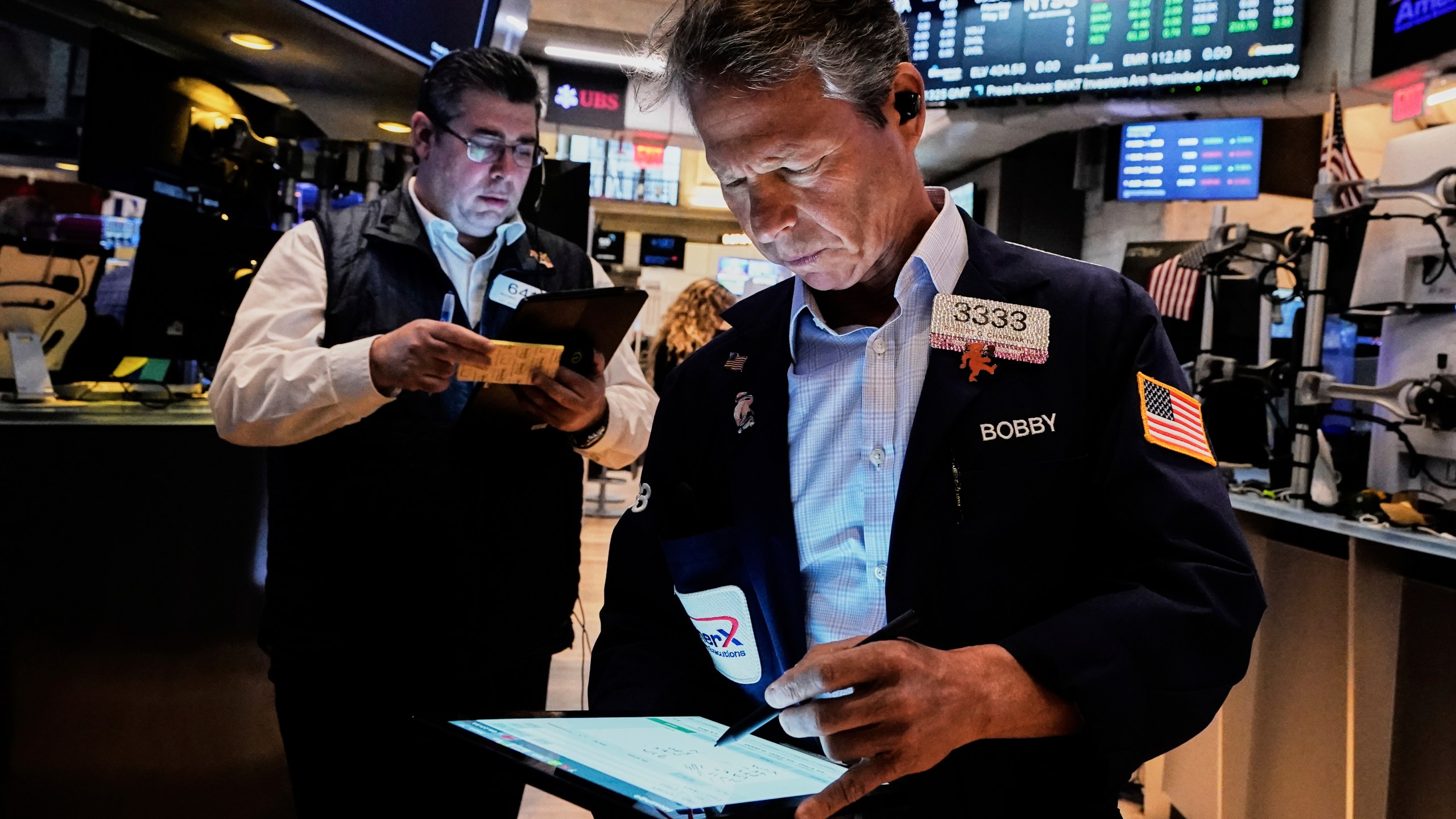 Traders Michael Capolino, left, and Robert Charmak work on the floor of the New York Stock Exchange, Monday, May 12, 2025. (AP Photo/Richard Drew)