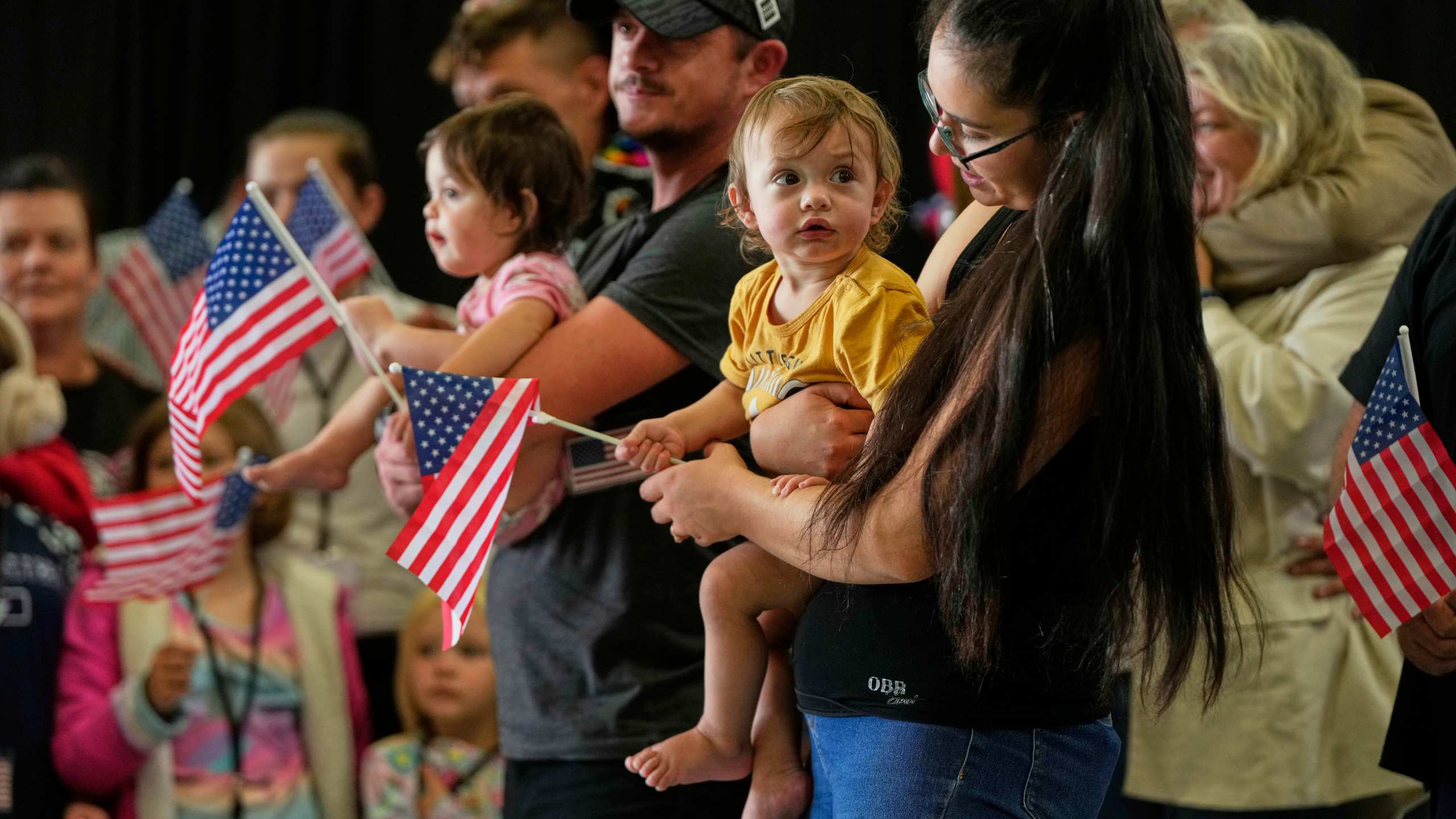 Afrikaner refugees from South Africa holding American flags arrive, Monday, May 12, 2025, at Dulles International Airport in Dulles, Va. (AP Photo/Julia Demaree Nikhinson)