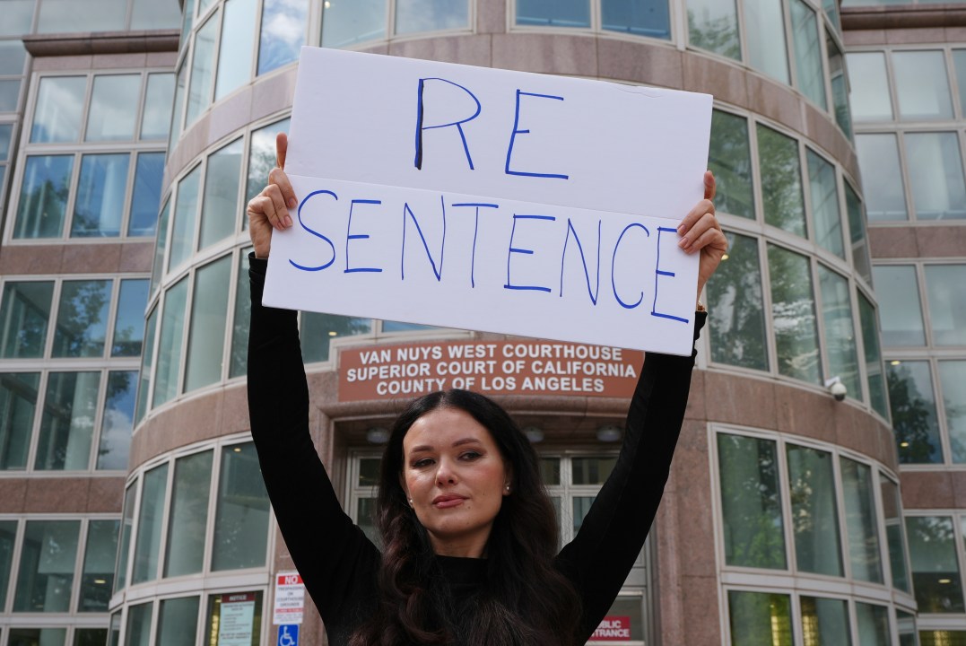 Natasha Blasick holds a sign in support of Erik and Lyle Menendez outside the Van Nuys Courthouse during a hearing in the brothers' case Tuesday, May 13, 2025, in Los Angeles. (AP Photo/Damian Dovarganes)