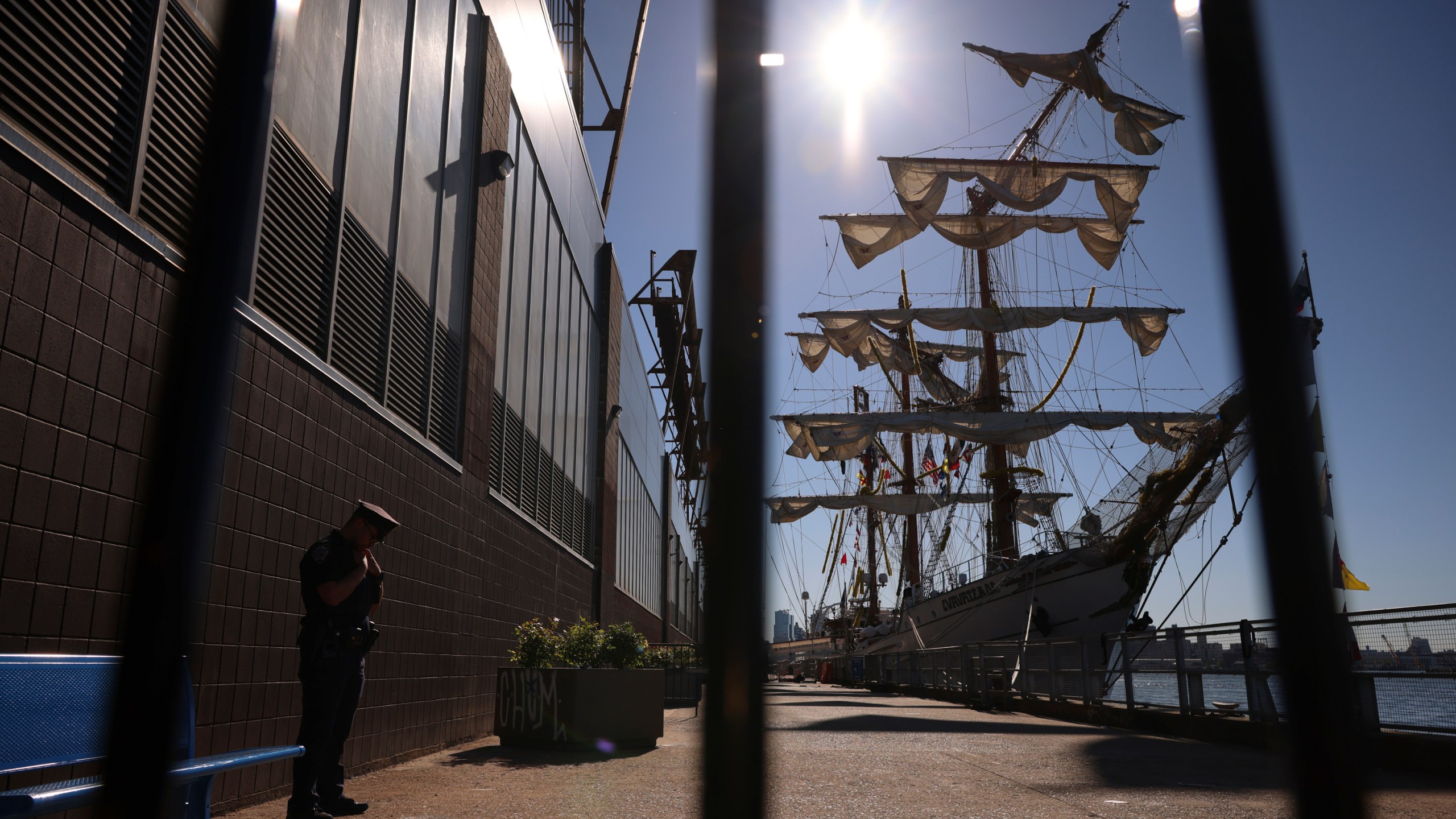 A New York Police officer stands watch on Pier 35 where the Cuauhtémoc, a masted Mexican Navy training ship that collided with the Brooklyn Bridge the night before, sits docked. (AP Photo/Yuki Iwamura)