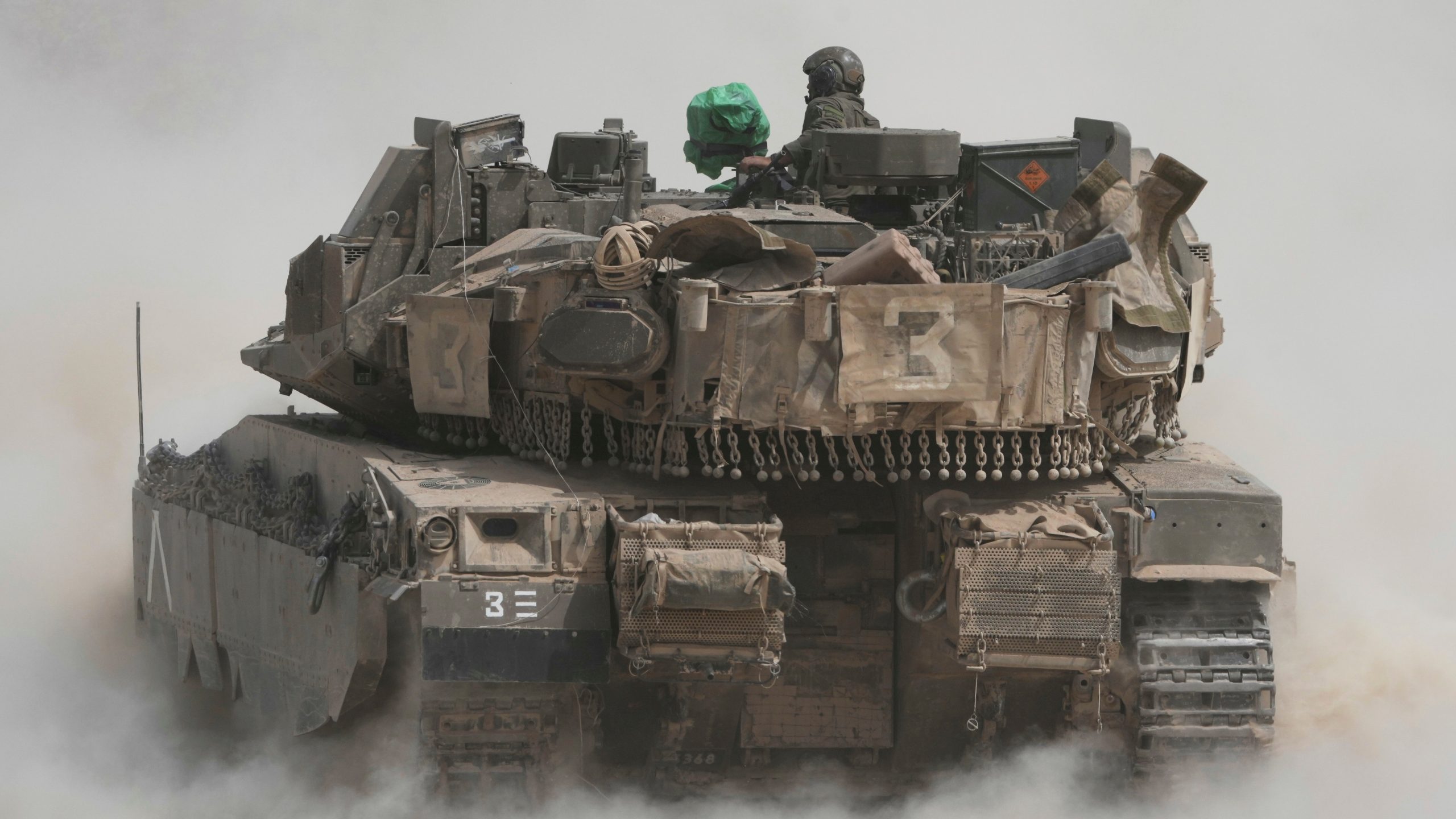 Israeli soldiers move tanks around staging area near the border with the Gaza Strip, in southern Israel, Sunday, May 18, 2025. (AP Photo/Ariel Schalit)