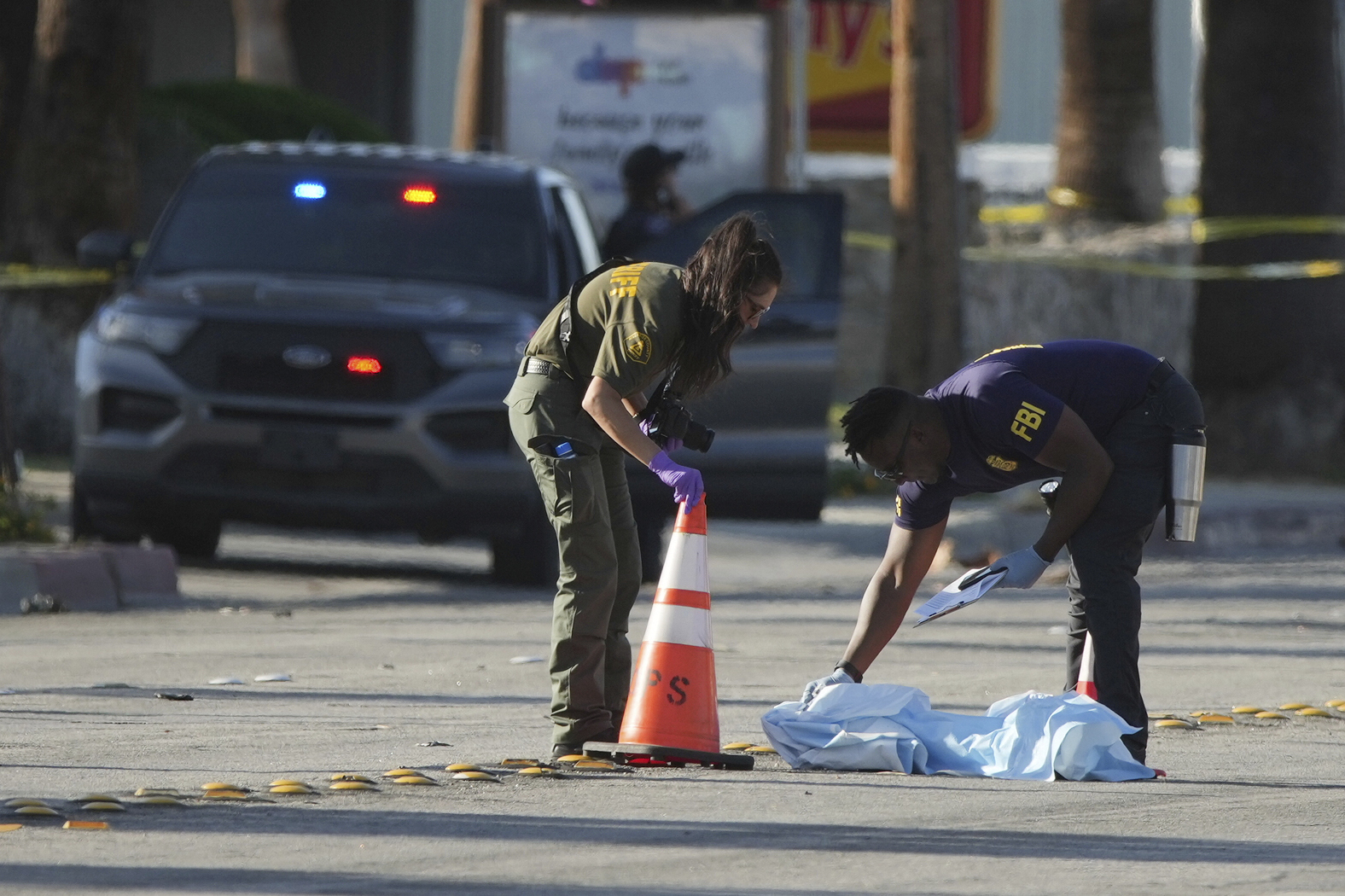 Investigators place a tarp over an item on a road near the site of an explosion in Palm Springs, Calif., on Saturday, May 17, 2025. (AP Photo/Eric Thayer)