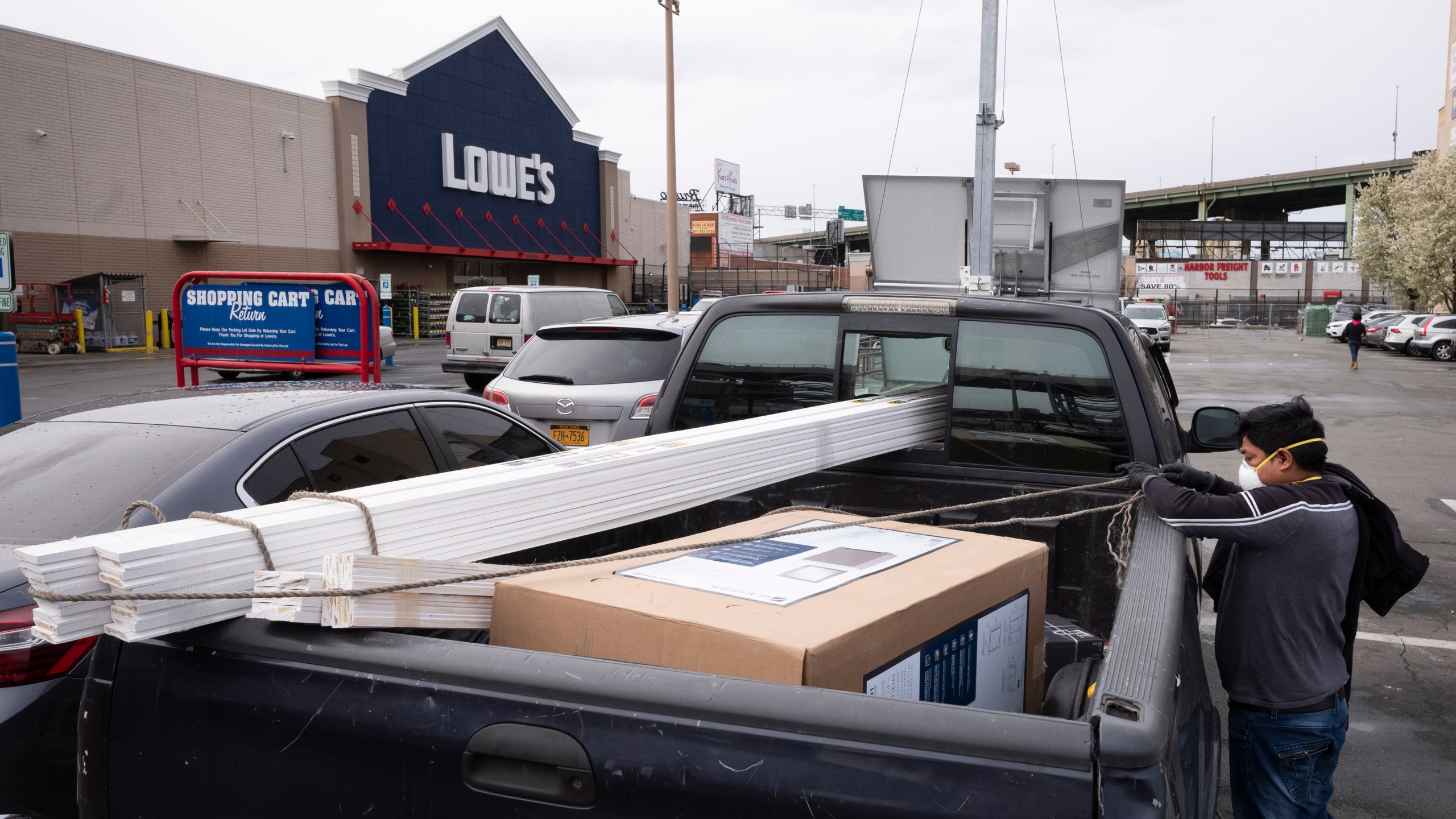 FILE - Lowe's customers wear masks as they load building supplies into their truck, Friday, April 3, 2020, during the coronavirus pandemic in New York. (AP Photo/Mark Lennihan, File)