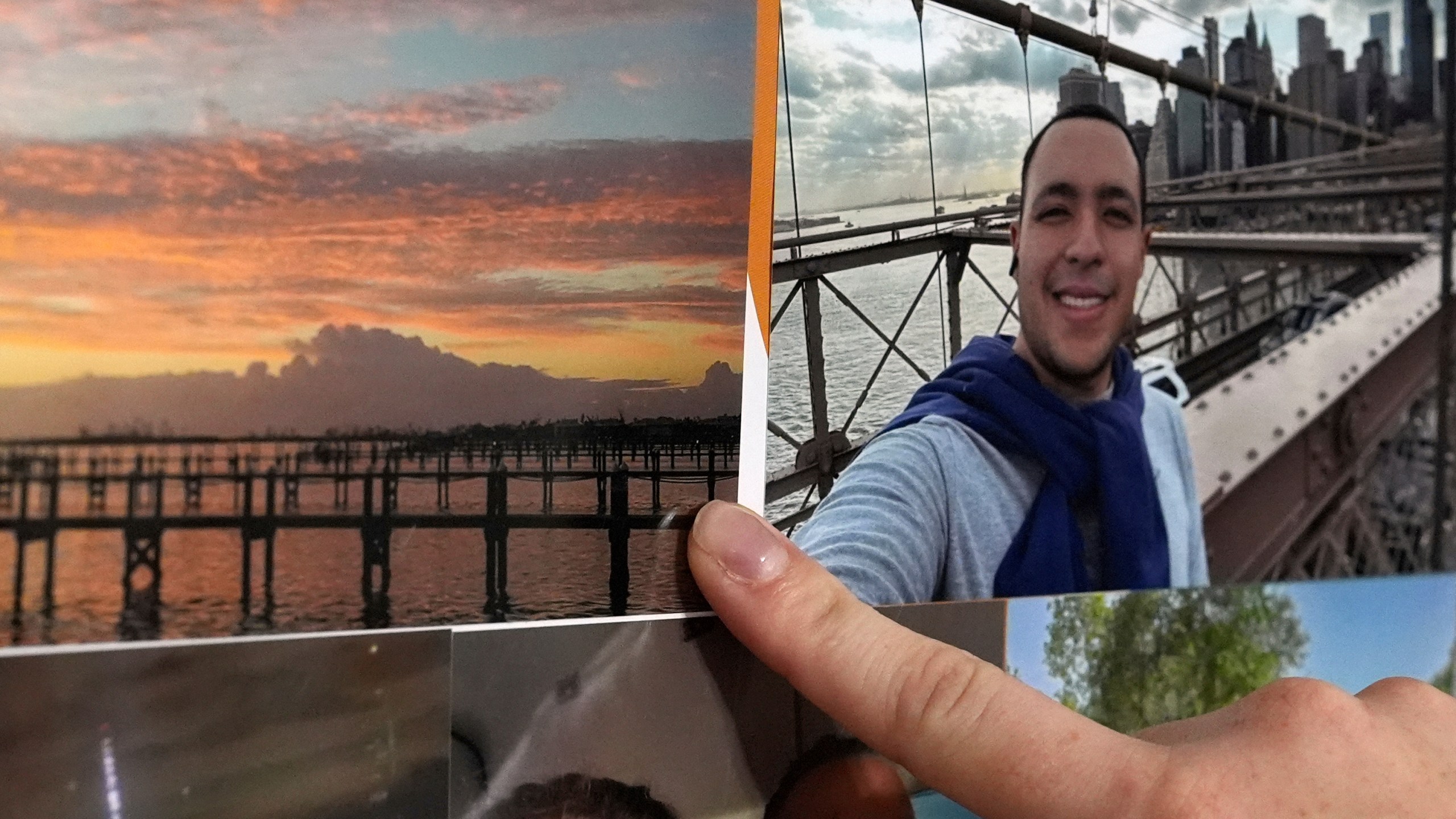 The girlfriend of Juan Serrano, a 28-year-old Colombian migrant with no criminal record who was detained Wednesday, May 21, 2025, at Miami Immigration Court after appearing for a hearing, points to a picture of the barrier island where the pair met while working on a cleanup and demolition crew following 2022's Hurricane Ian, inside their apartment in Oakland Park, Fla. (AP Photo/Rebecca Blackwell)