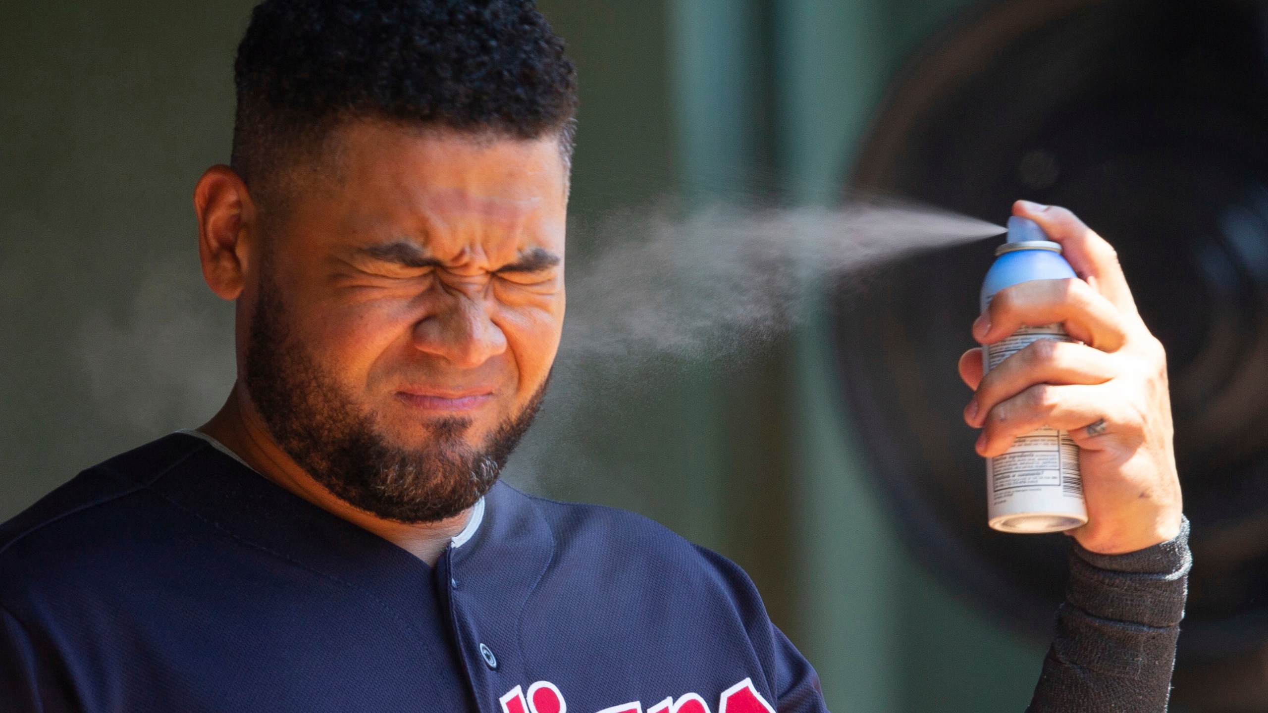 FILE - Cleveland Indians right fielder Melky Cabrera sprays sunscreen before a baseball game against the Texas Rangers, Sunday, July 22, 2018, in Arlington, Texas. (AP Photo/Sam Hodde, File)