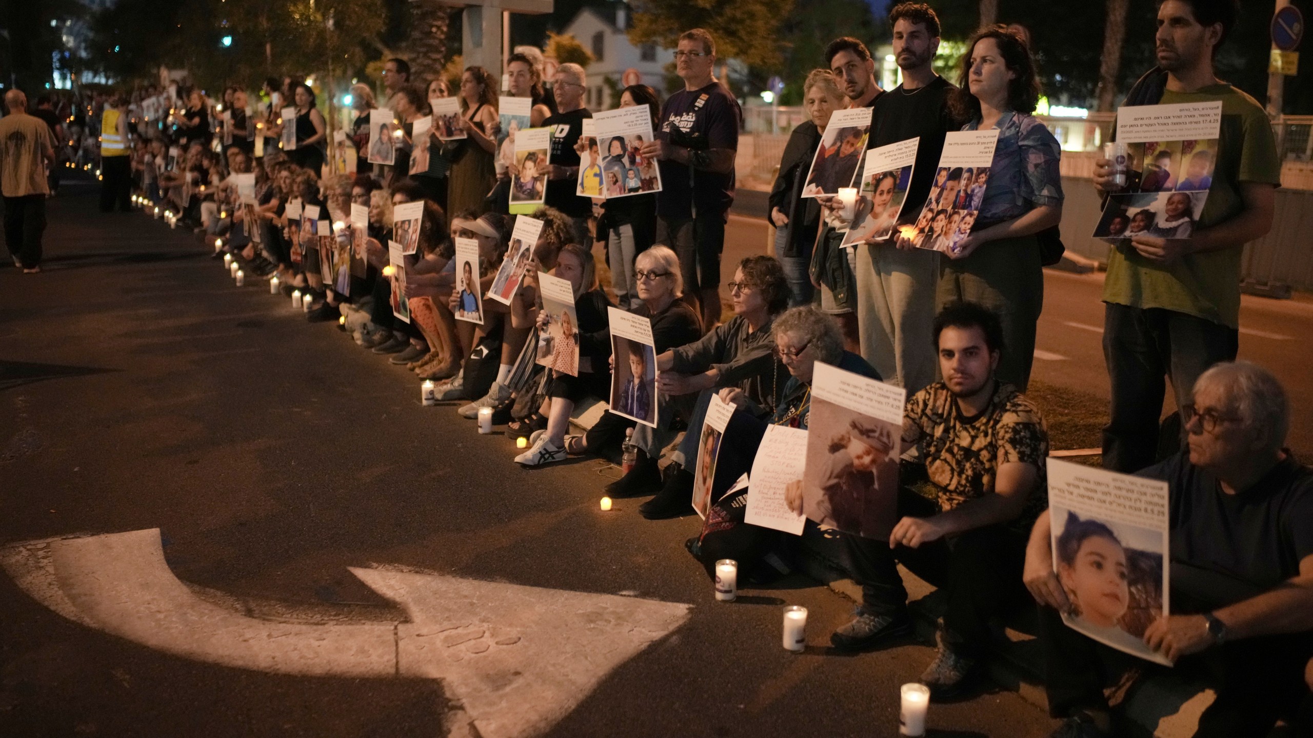 Israeli activists hold photos of Palestinian children killed during the Israel air and ground operation in the Gaza Strip, calling for an end to the war, during a protest in Tel Aviv, Israel, Saturday, May 24, 2025. (AP Photo/Leo Correa)