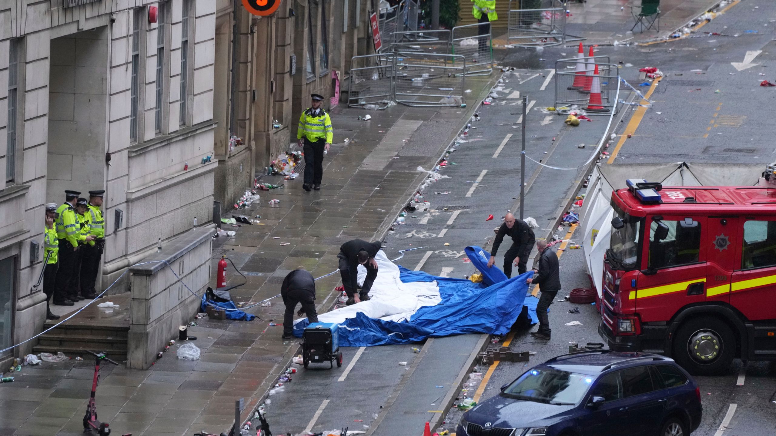 police work the scene where a car drove into a crowd