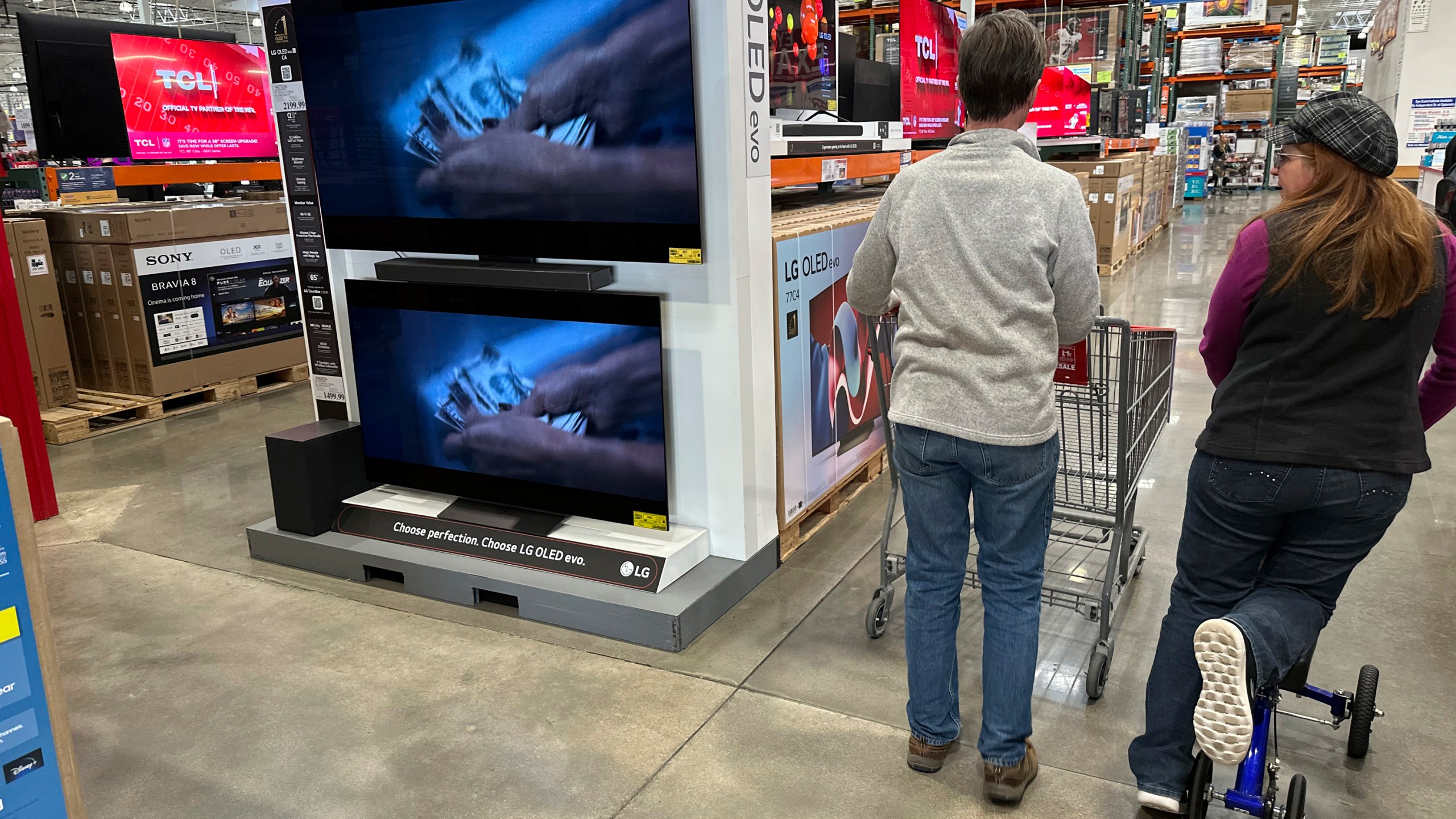 FILE - Shoppers pass by large-screen televisions on display in a Costco warehouse Thursday, Dec. 19, 2024, in Colorado Springs, Colo. (AP Photo/David Zalubowski, File)