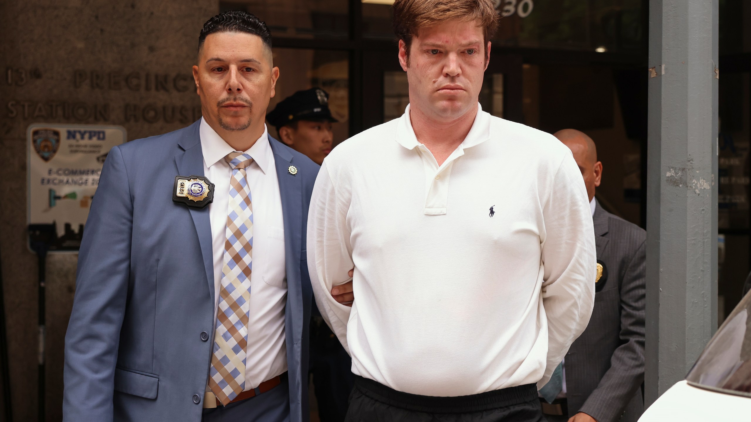 William Duplessie, right, is escorted out of the New York Police 13th Precinct after turning himself in on charges of kidnapping and false imprisonment, Tuesday, May 27, 2025, in New York. (AP Photo/Yuki Iwamura)