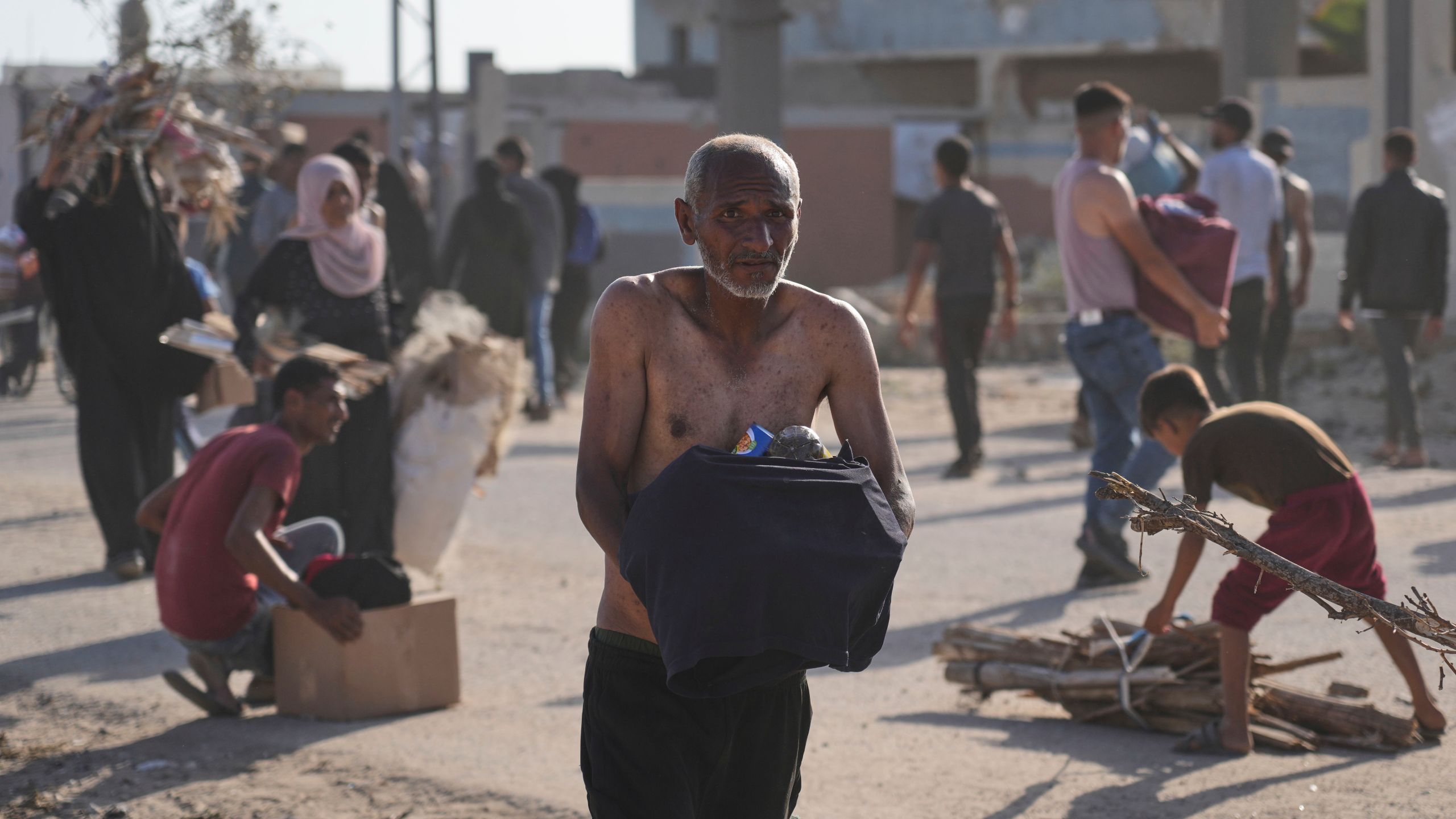 People carry boxes containing food and humanitarian aid packages