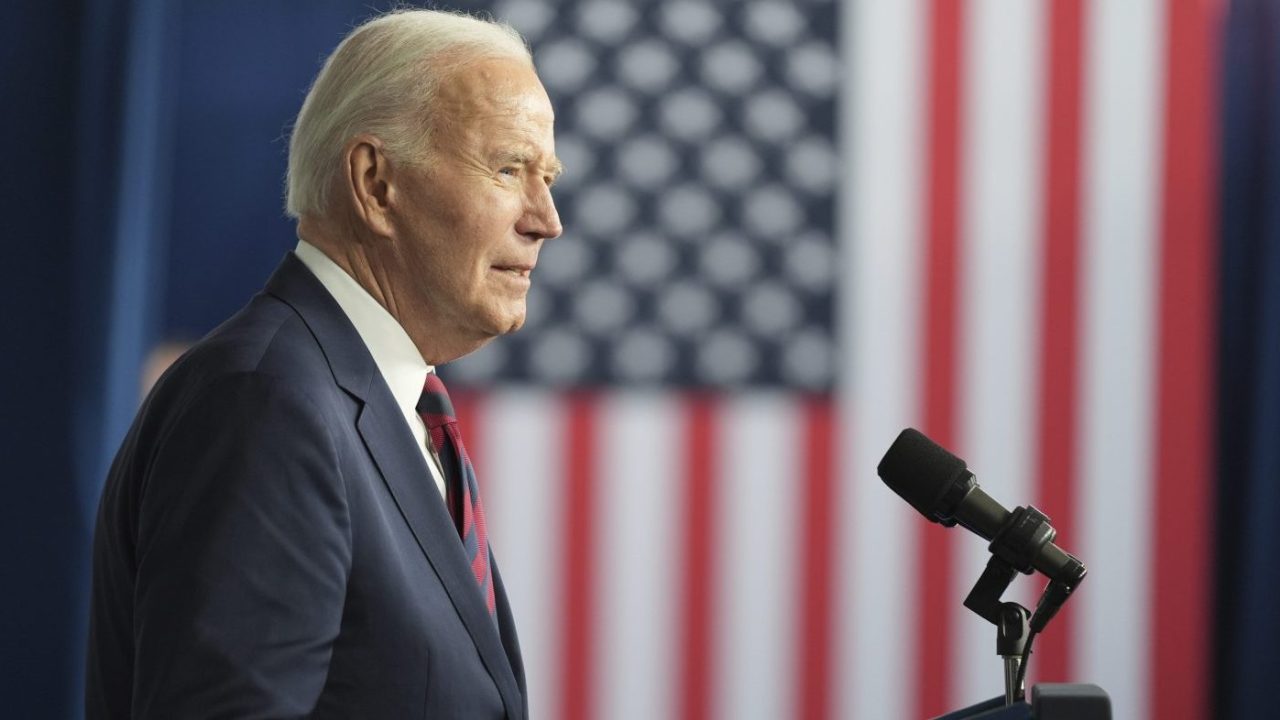 Biden speaks at a podium in front of a US flag