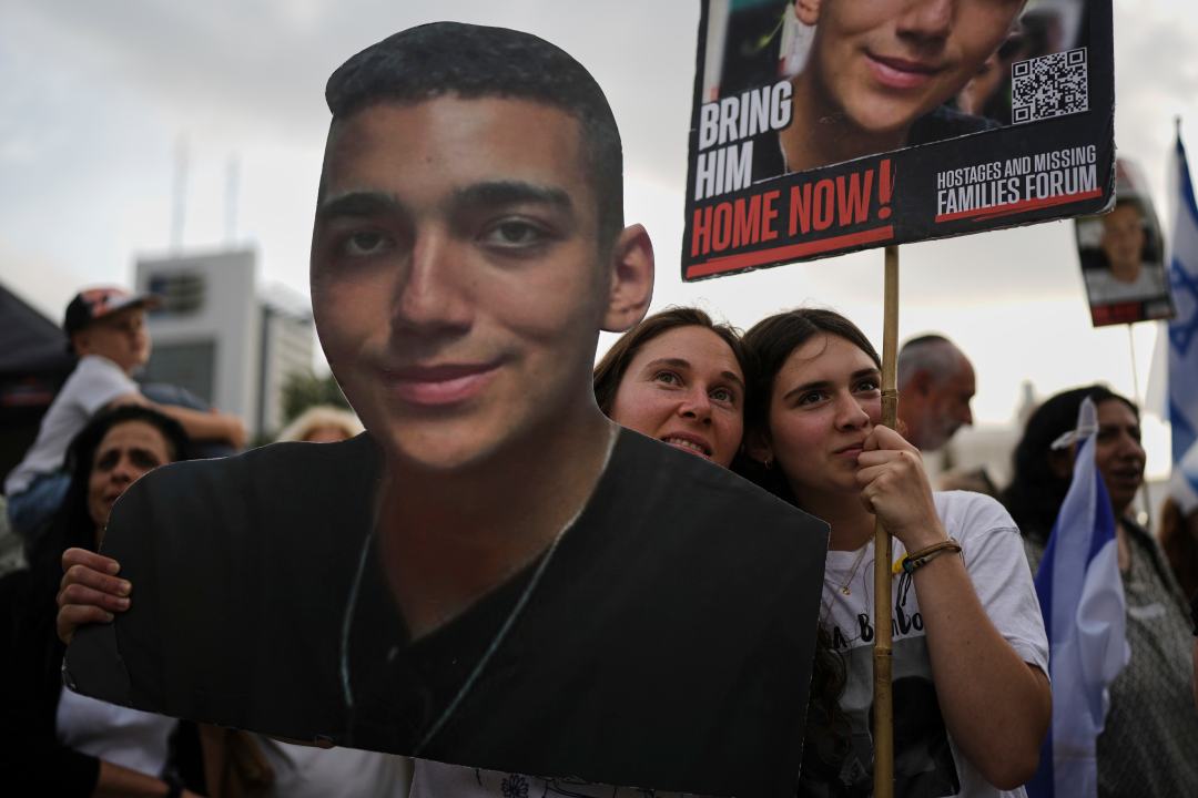 People watch a live broadcast of Israeli-American soldier Edan Alexander