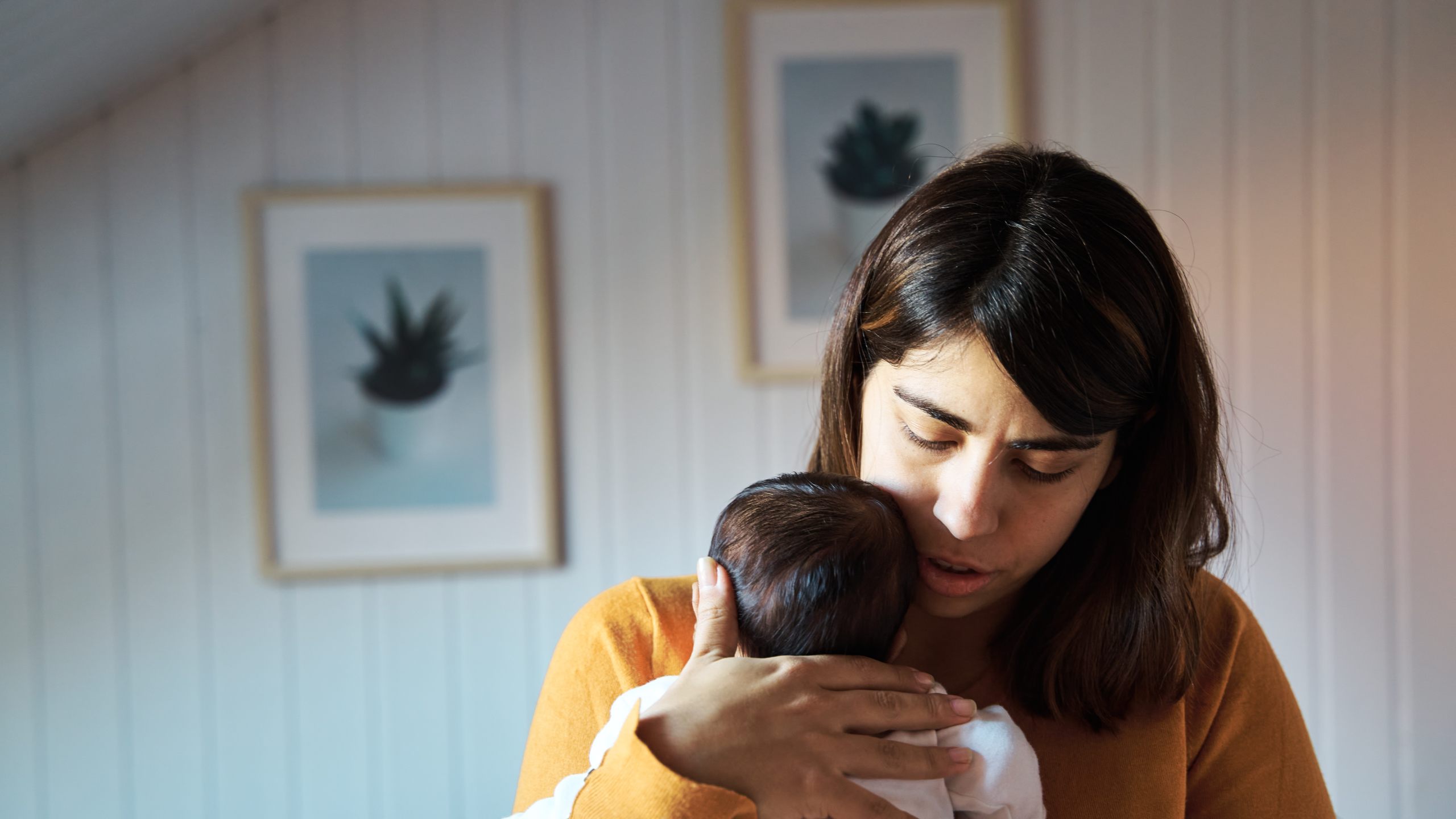 Front view of a mother singing a lullaby to her newborn baby for a nap.