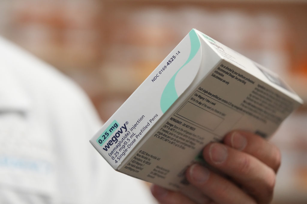 A pharmacist holds a box of Novo Nordisk A/S Wegovy brand semaglutide medication arranged at a pharmacy in Provo, Utah, US, on Monday, Nov. 27, 2023. Prescriptions of appetite suppressing GLP-1 weight-loss drugs skyrocketed 300% from 2020 to 2022. (Photographer: George Frey/Bloomberg via Getty Images)