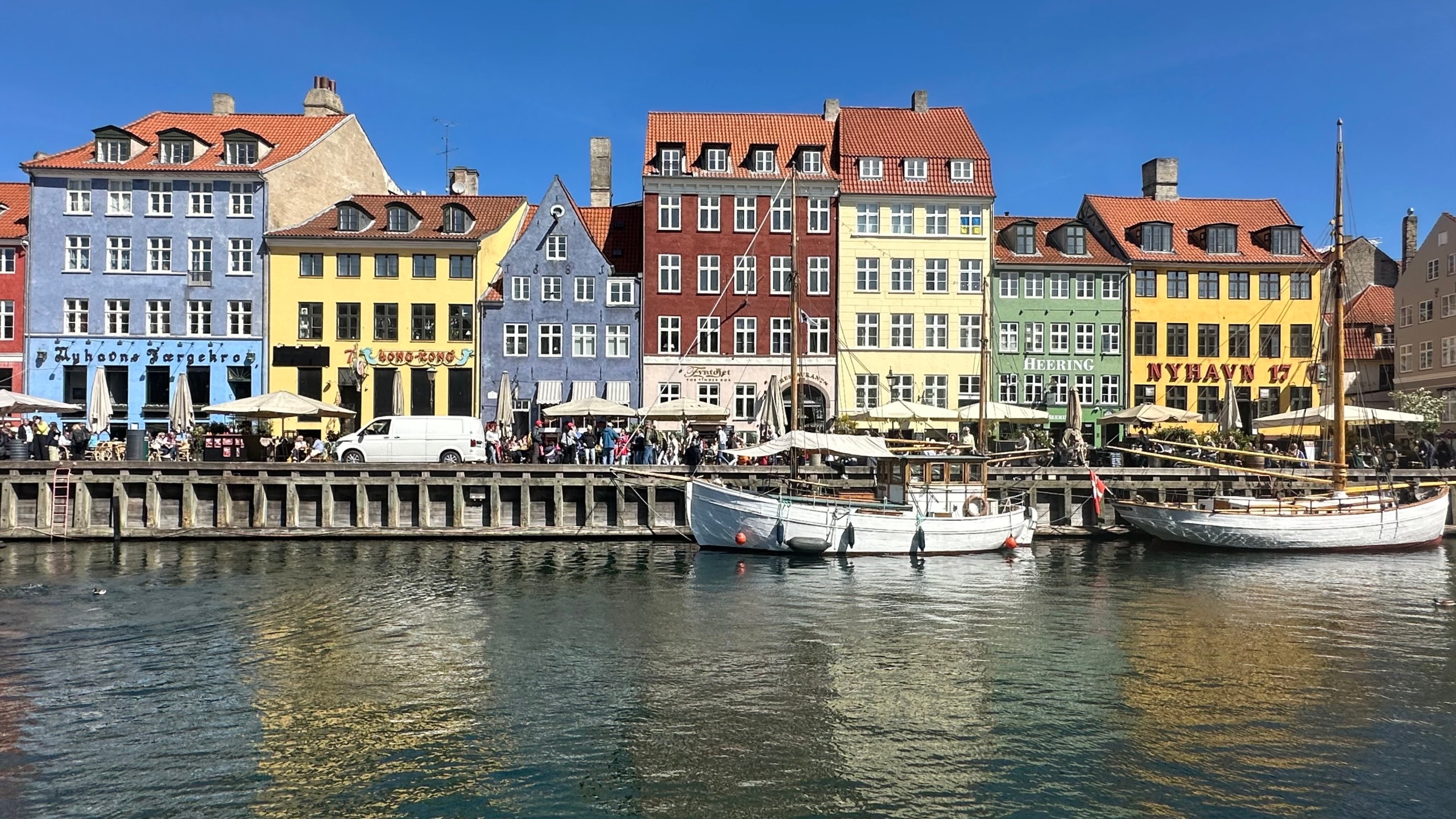 Passers-by walk along the Nyhavn (new harbor). Nyhavn, with its colorful little houses, is one of the most important sights in the Danish capital.