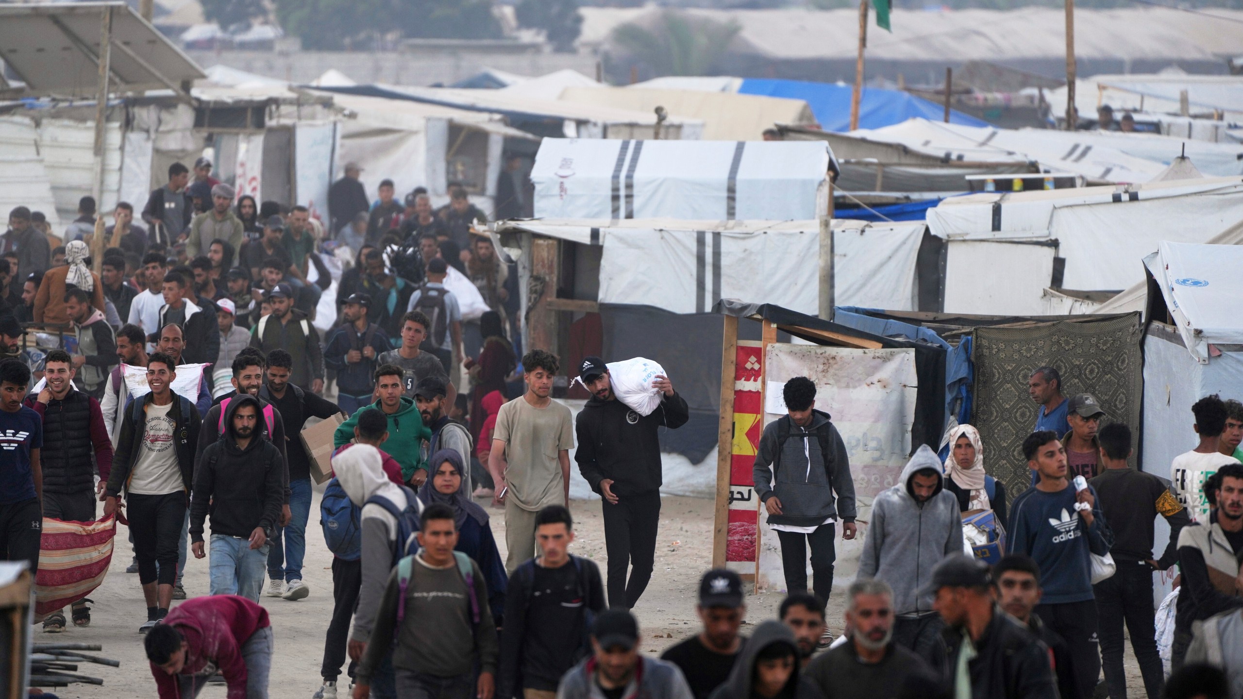 Palestinians carry bags filled with food and humanitarian aid