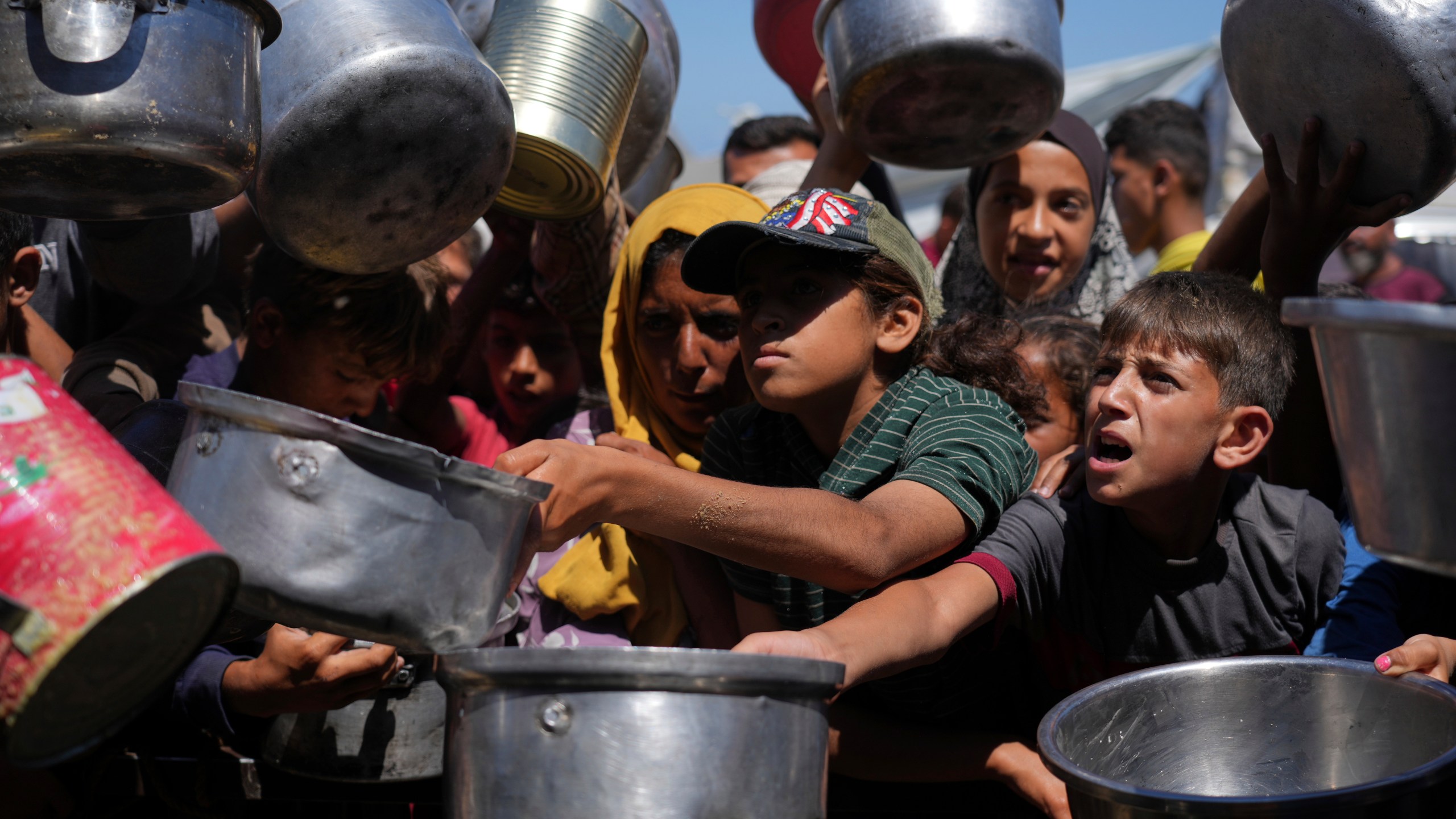 Palestinians struggle to get donated food at a community kitchen