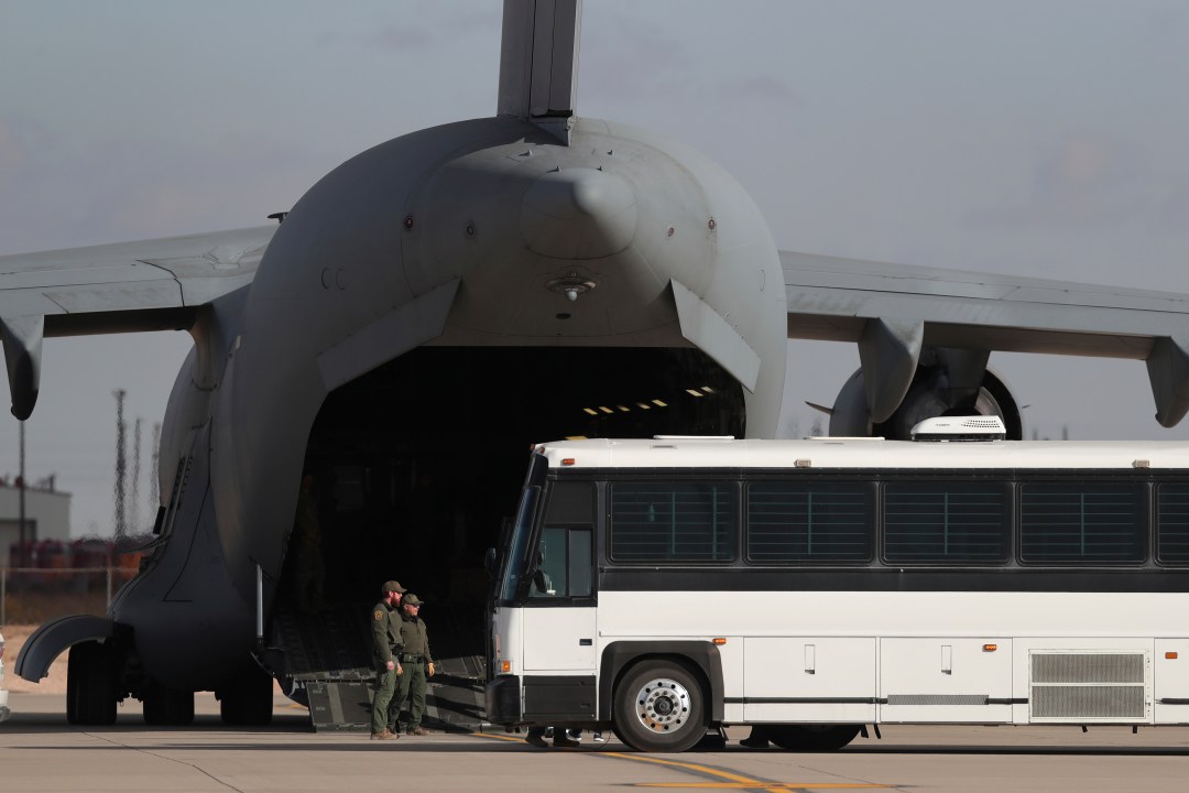 FILE - A military aircraft waits for migrants to board from a bus at Fort Bliss in El Paso, Tx., Thursday, Jan. 30, 2025, before deporting them to Guatemala. (AP Photo/Christian Chavez, File)