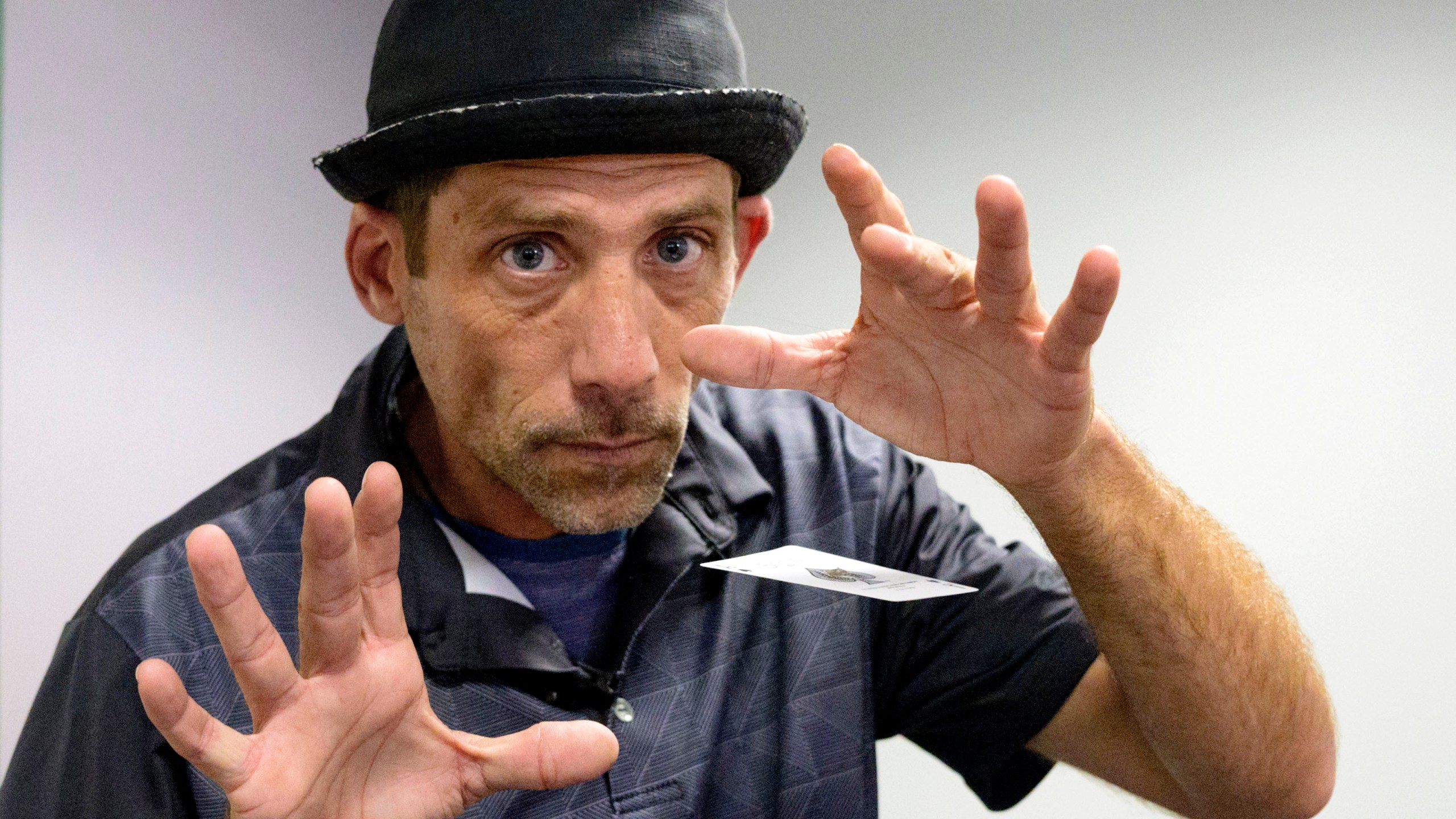 FILE - Paul Carpenter, a New Orleans magician, performs card tricks during an interview in New Orleans, Feb. 23, 2024. (AP Photo/Matthew Hinton, File)