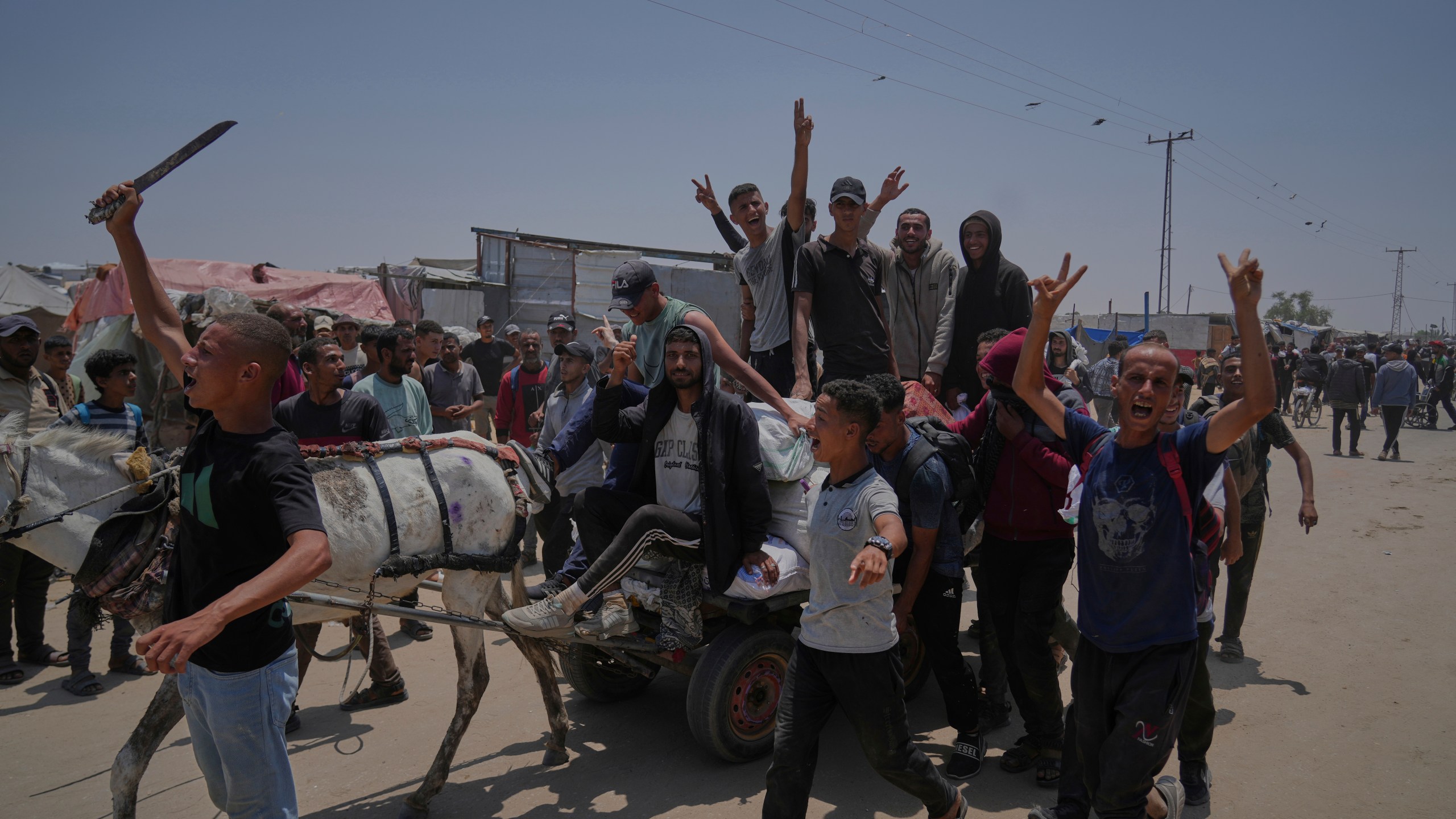 Palestinians carry bags containing food and humanitarian aid packages delivered by the Gaza Humanitarian Foundation, a U.S.-backed organization, in Rafah, southern Gaza Strip, Sunday, June 8, 2025. (AP Photo/Abdel Kareem Hana)