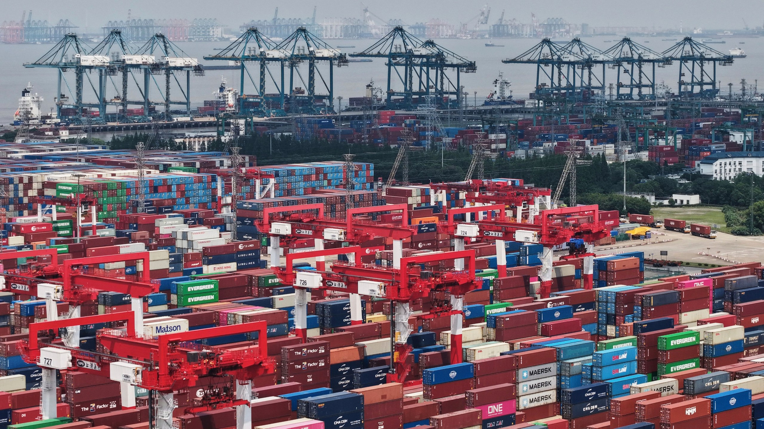 Trucks loaded with container move through a container terminal port in Shanghai, China Monday, June 9, 2025. (Chinatopix Via AP)