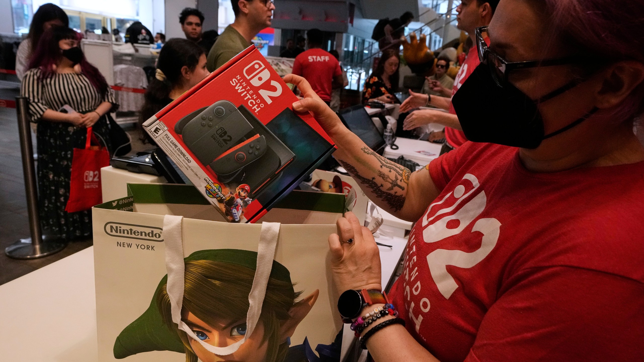 A Nintendo store cashier places a Switch 2 in a bag for a customer at the Nintendo store in New York's Rockefeller Center, Thursday, June 5, 2025. (AP Photo/Richard Drew)