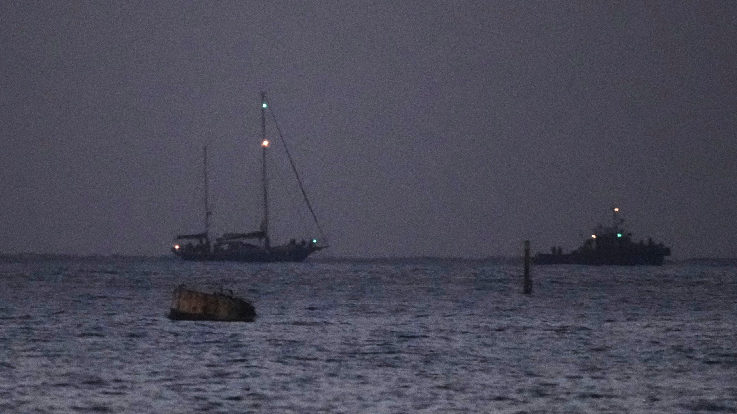 The Gaza-bound aid boat, Madleen, left, under escort of Israeli naval forces making its way toward Ashdod Port in southern Israel after being seized by Israeli forces, Monday, June 9, 2025. (AP Photo/Leo Correa)