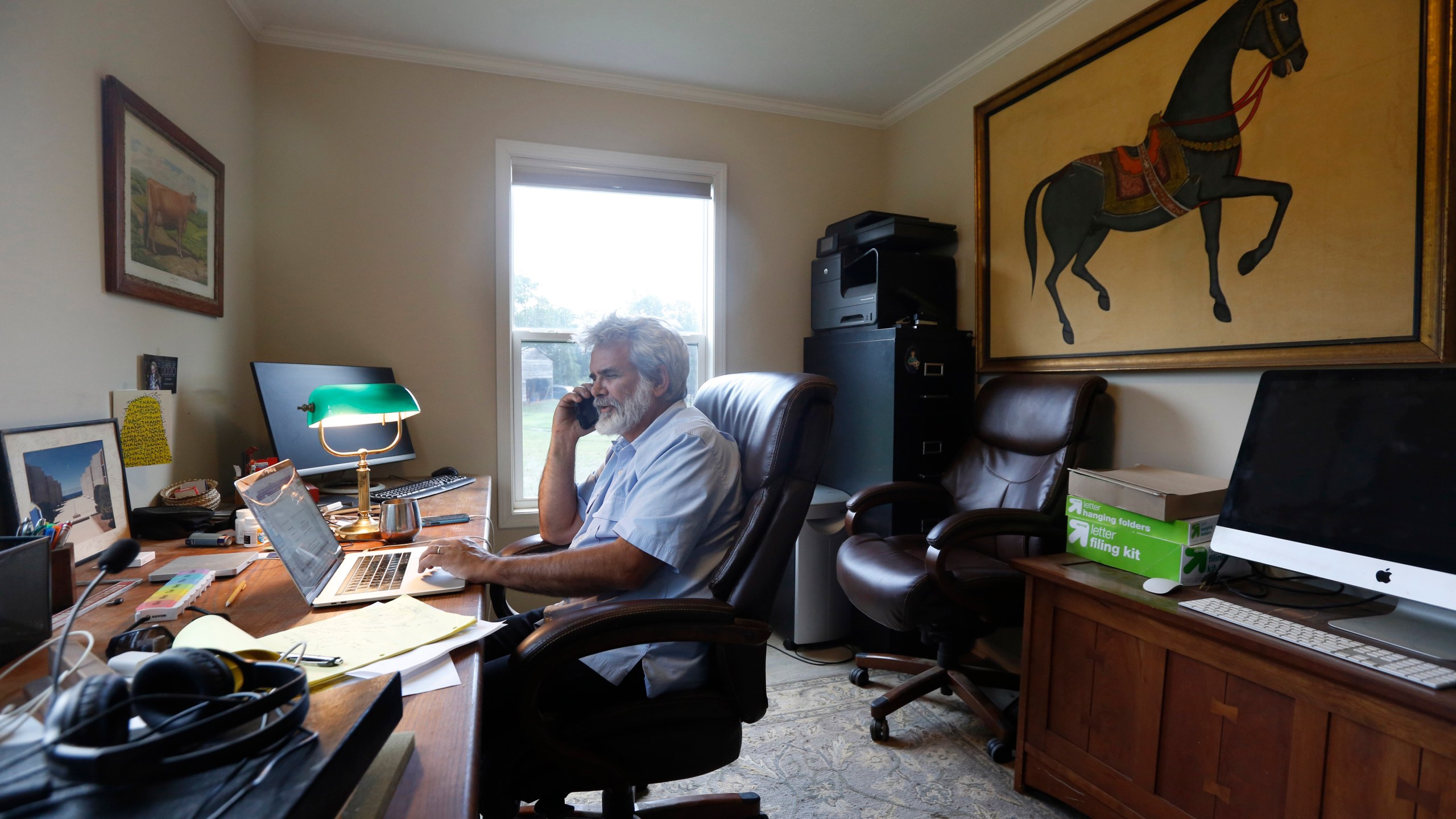 FILE - Dr. Robert Malone works in his office on his horse farm in Madison, Va., July 22, 2020. (AP Photo/Steve Helber, File)