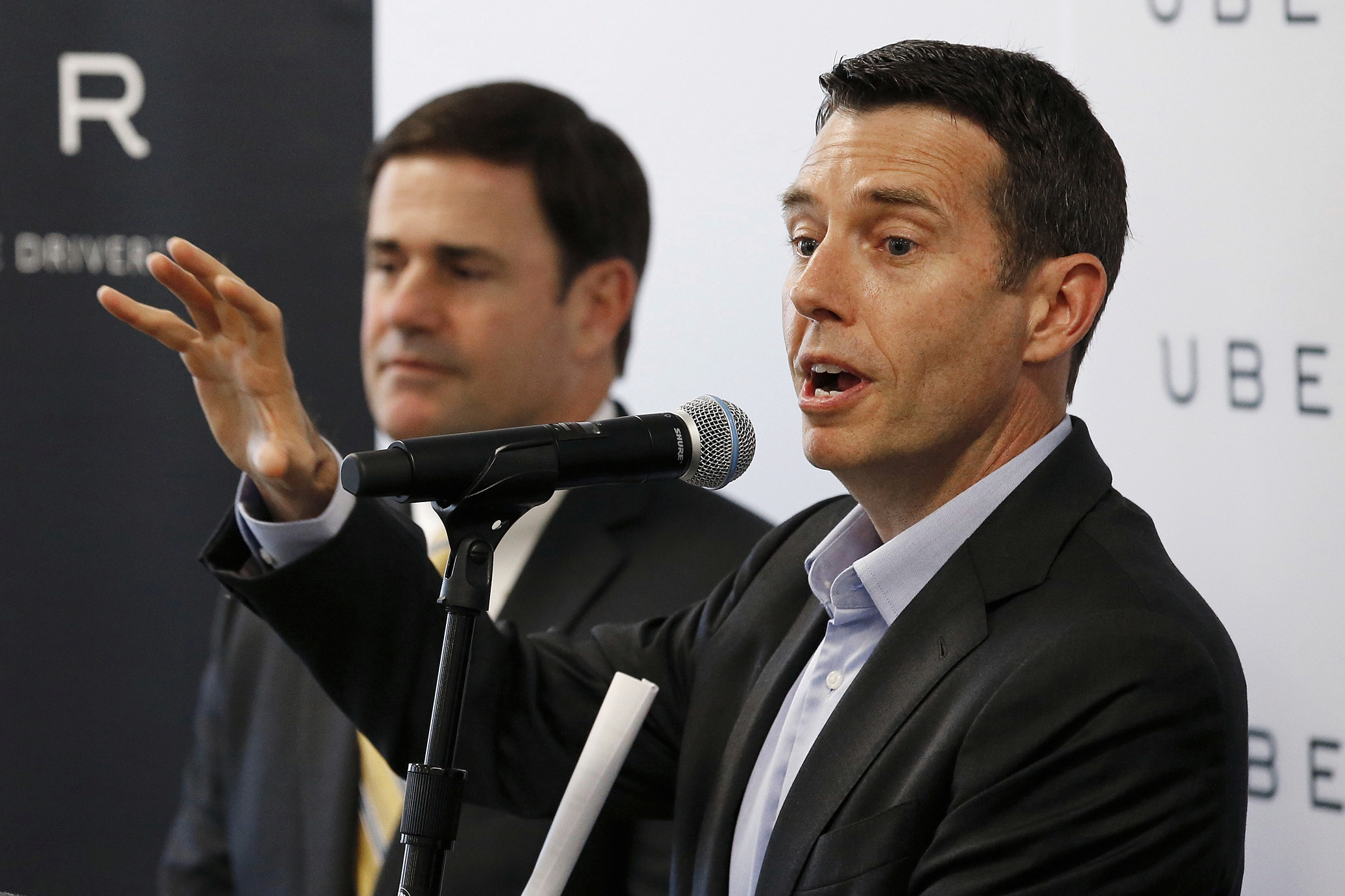 FILE - David Plouffe, right, Uber senior vice president of policy and communications, talks about the Uber expansion in Phoenix as Arizona Gov. Doug Ducey listens during a news conference announcing the opening of the new Uber offices June 11, 2015, in Phoenix. (AP Photo/Ross D. Franklin, File)