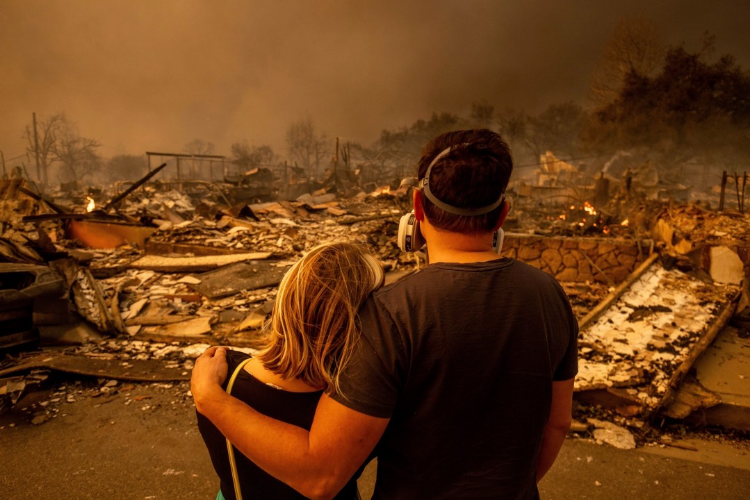 Couple looks at their fire-damaged home in Altadena, Calif.