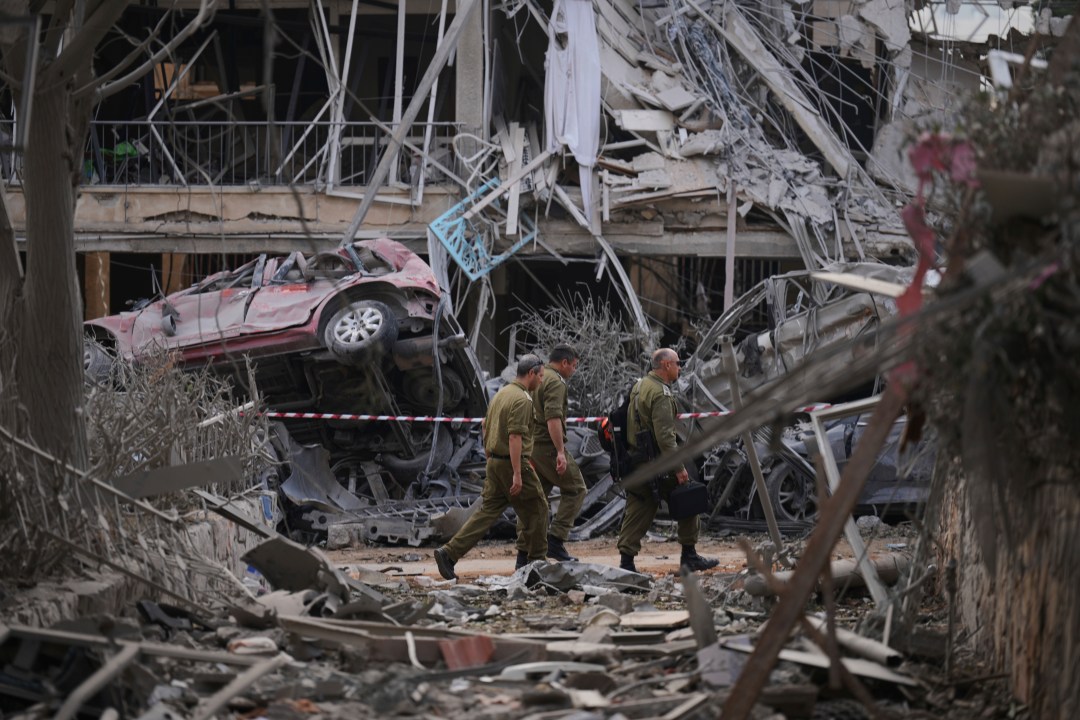 Israeli security forces inspect destroyed residential buildings in Tel Aviv.