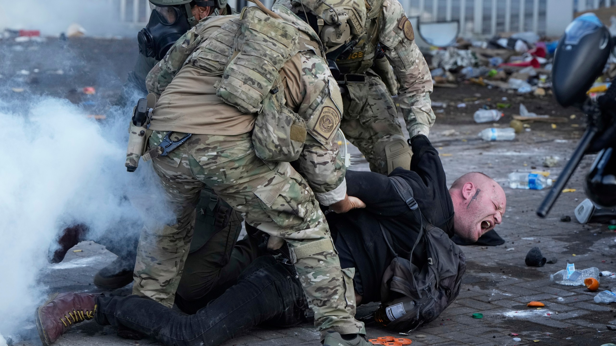 U.S. Customs and Border Protection agents detain a man outside the U.S. Immigration and Customs building during a protest Saturday, June 14, 2025, in Portland, Ore. (AP Photo/Jenny Kane)