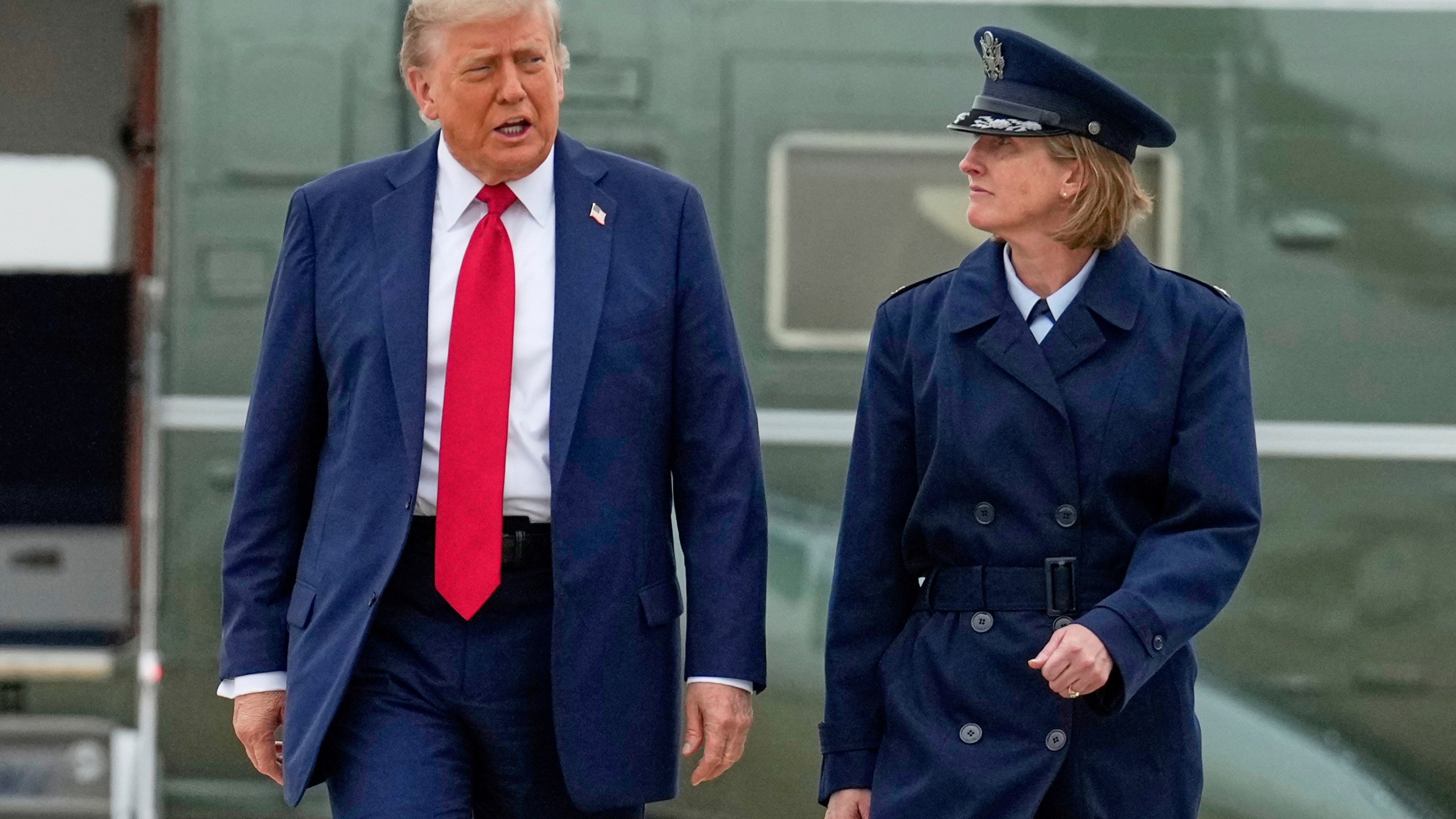President Donald Trump, left, escorted by Air Force Col. Angela F. Ochoa, Commander, 89th Airlift Wing, walks from Marine One to board Air Force One, Sunday, June 15, 2025, at Joint Base Andrews, Md., for a trip to Canada to attend the G7 Summit. (AP Photo/Mark Schiefelbein)