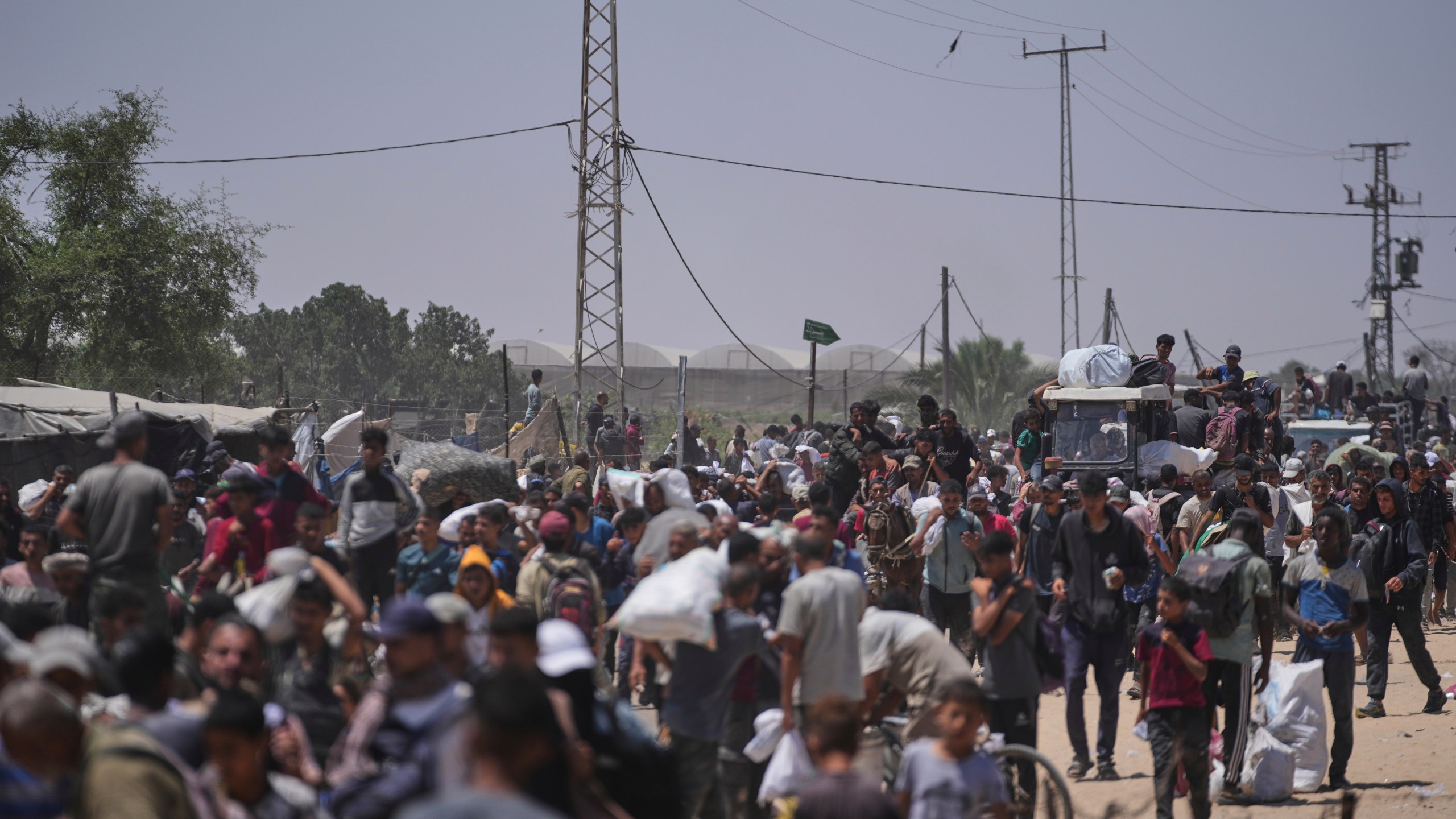 Palestinians carry bags containing food and humanitarian aid packages delivered by the Gaza Humanitarian Foundation, a U.S.-backed organization, in Rafah, southern Gaza Strip, Monday, June 16, 2025. (AP Photo/Abdel Kareem Hana)