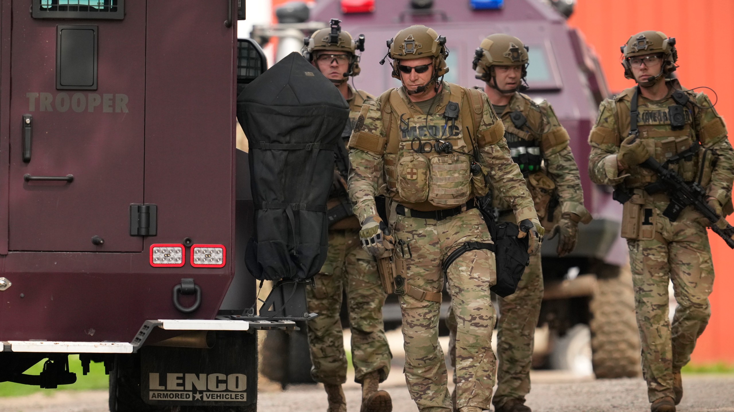 Members of law enforcement agencies search for shooting suspect, Vance Boelter, at a house Sunday, June 15, 2025, in Belle Plaine, Minn. (AP Photo/George Walker IV)