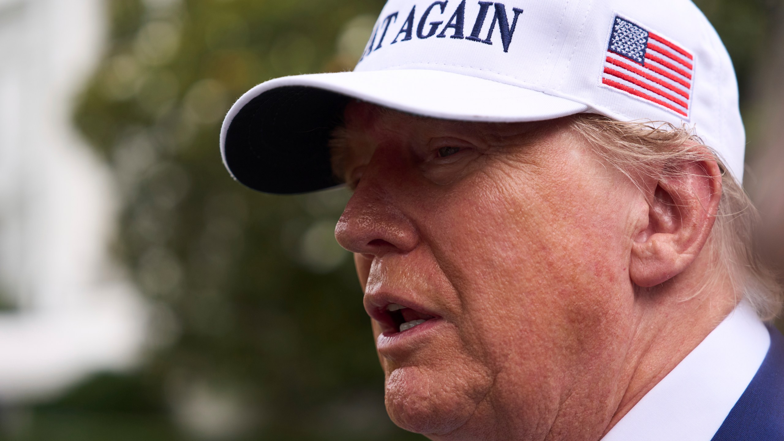 President Donald Trump speaks with reporters as a flag pole is installed on the South Lawn of the White House, Wednesday, June 18, 2025, in Washington. (AP Photo/Evan Vucci)