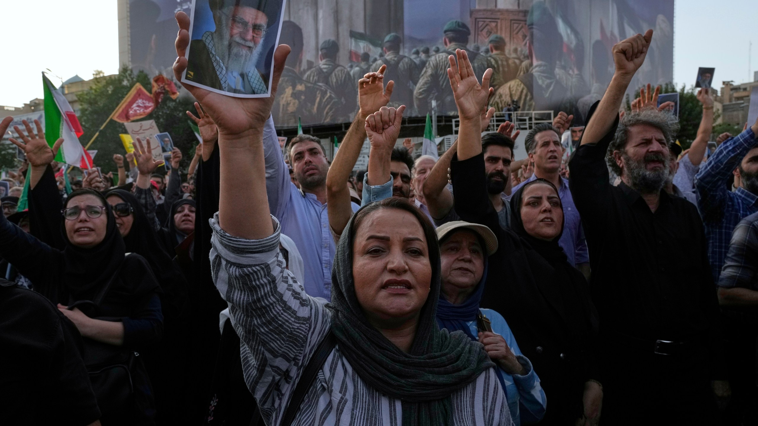 Protesters chant slogans as one of them holds up a poster of the Iranian Supreme Leader Ayatollah Ali Khamenei in a protest following the U.S. attacks on nuclear sites in Iran, in Tehran, Iran, Sunday, June 22, 2025. (AP Photo/Vahid Salemi)