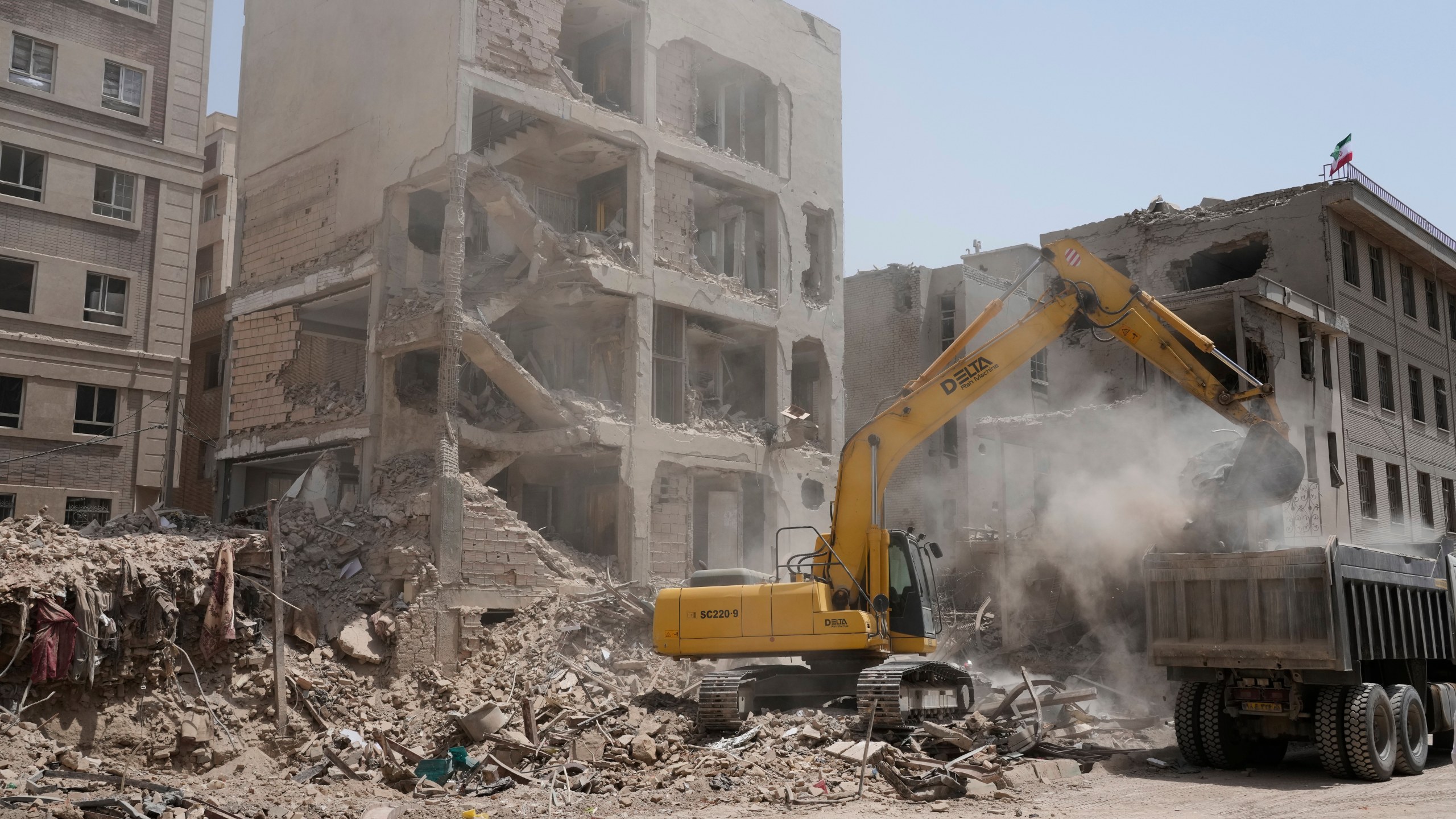 An excavator removes the rubble of a destroyed building hit by an Israeli airstrike on early Tuesday, in Tehran, Iran, Thursday, June 26, 2025. (AP Photo/Vahid Salemi)