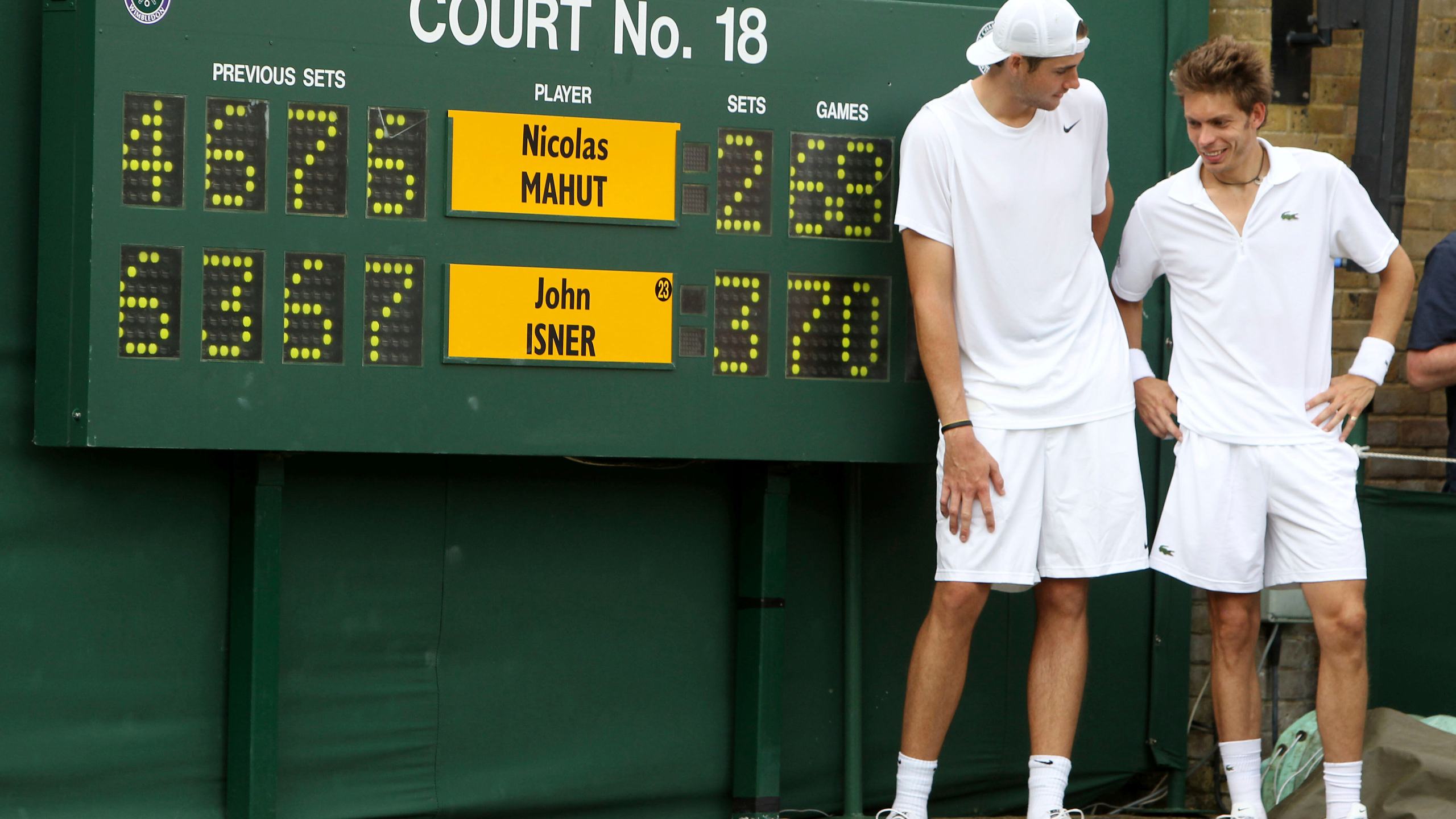 FILE - John Isner of the US and France's Nicolas Mahut, right, pose for a photo next to the scoreboard following their epic men's singles match at the All England Lawn Tennis Championships at Wimbledon, Thursday, June 24, 2010. (AP Photo/Alastair Grant,Pool,File)