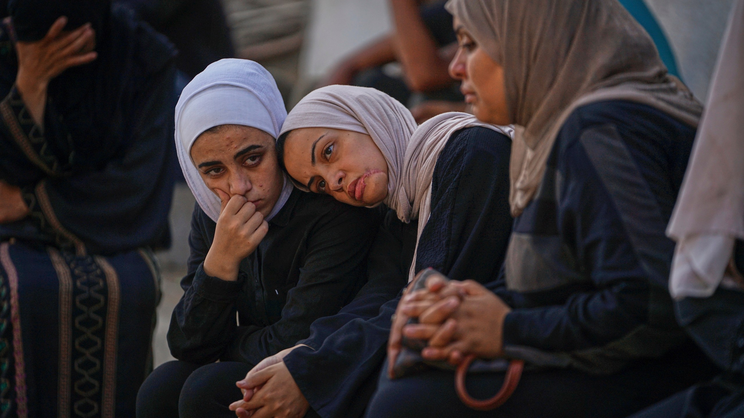 Women wait for relatives' burials at a hospital in Gaza