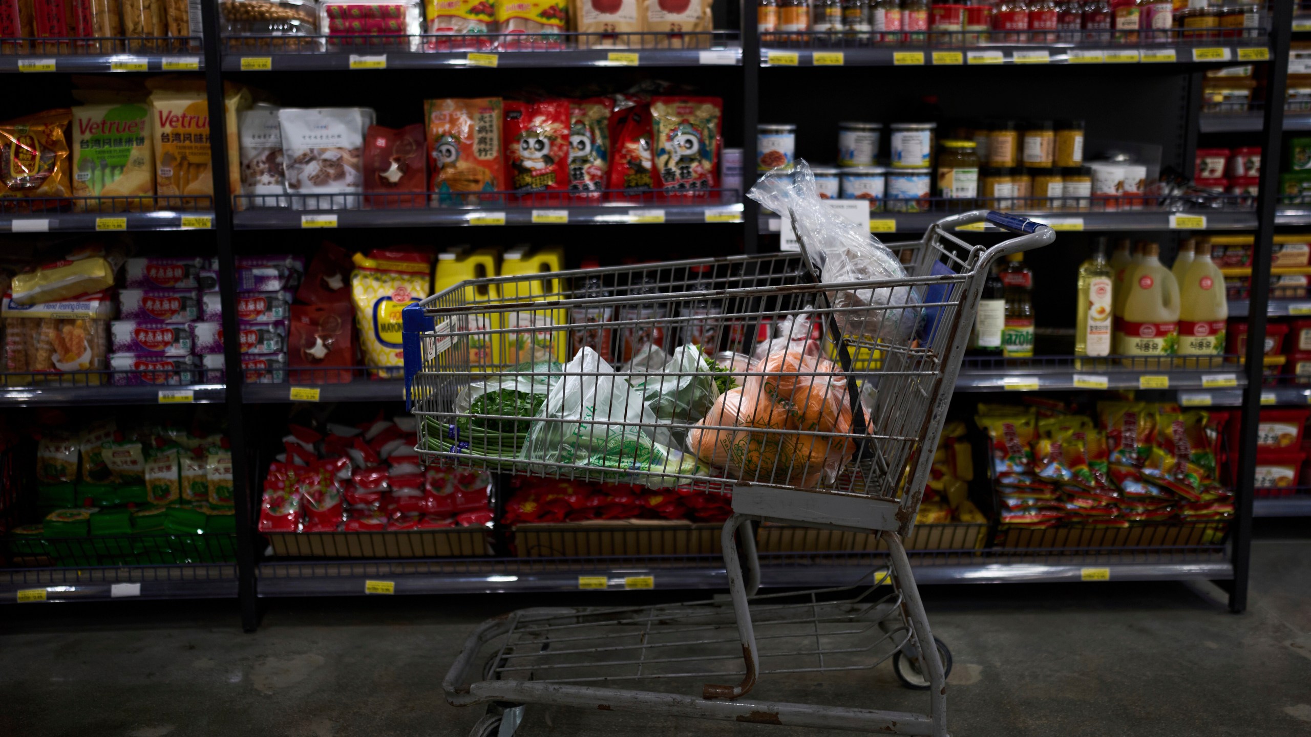 FILE - A shopping cart filled with groceries sits in an aisle at an Asian grocery store in Rowland Heights, Calif., Thursday, April 3, 2025. (AP Photo/Jae C. Hong, File)