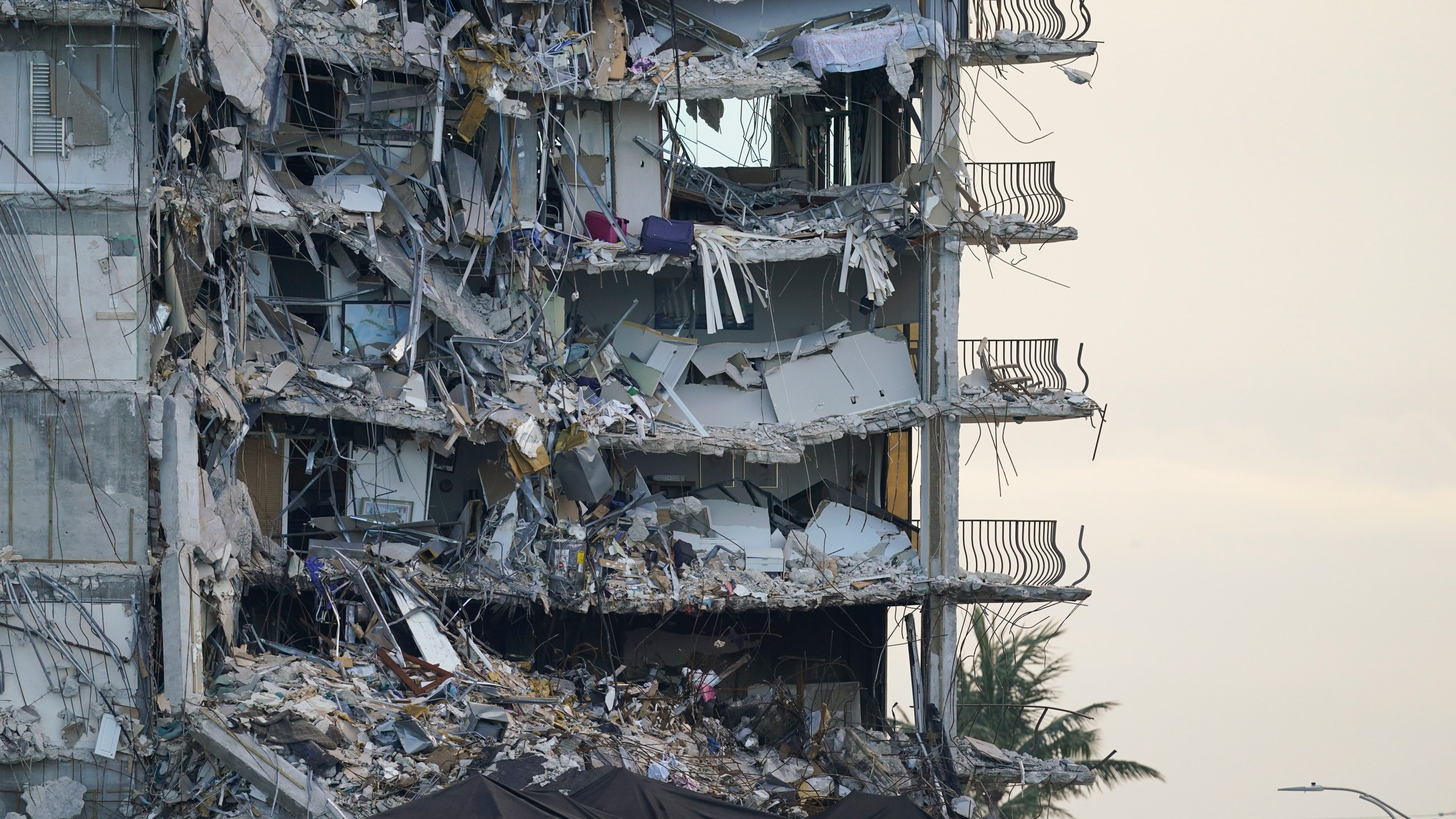 FILE - A giant tarp, bottom, covers a section of rubble at the Champlain Towers South condo building, July 4, 2021, in Surfside, Fla. (AP Photo/Lynne Sladky, File)